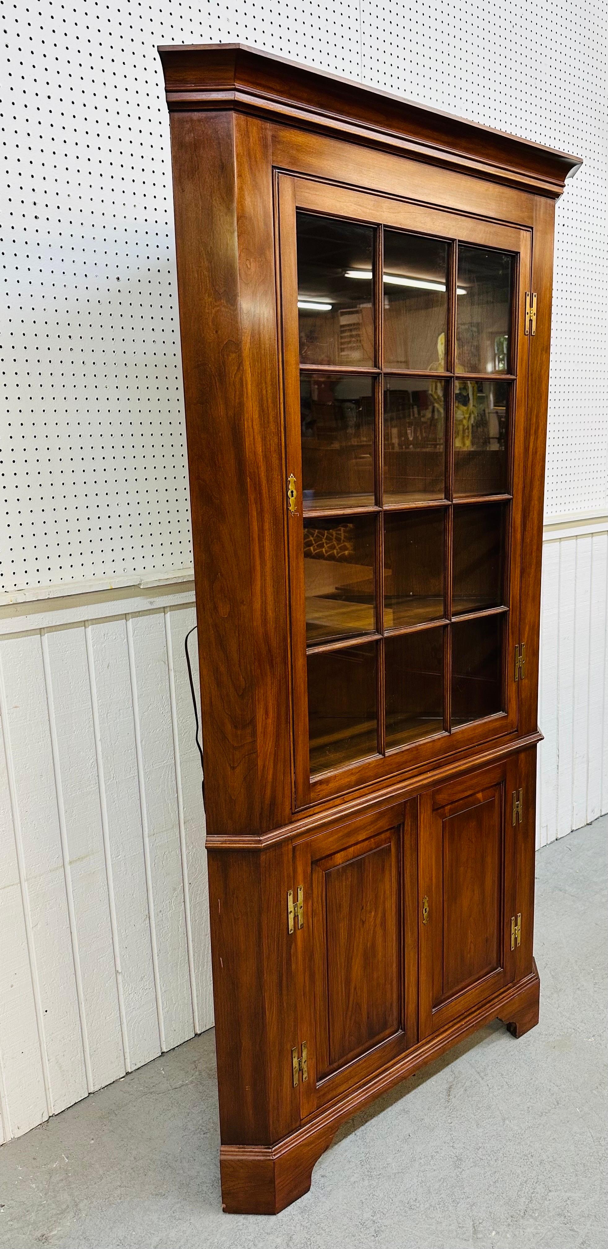 This listing is for a Vintage Henkel Harris Cherry Corner Cabinet. Featuring an antique style design, a glass locking door that opens up to three shelves, interior light, bottom locking doors that open up to more storage space, original key, and a