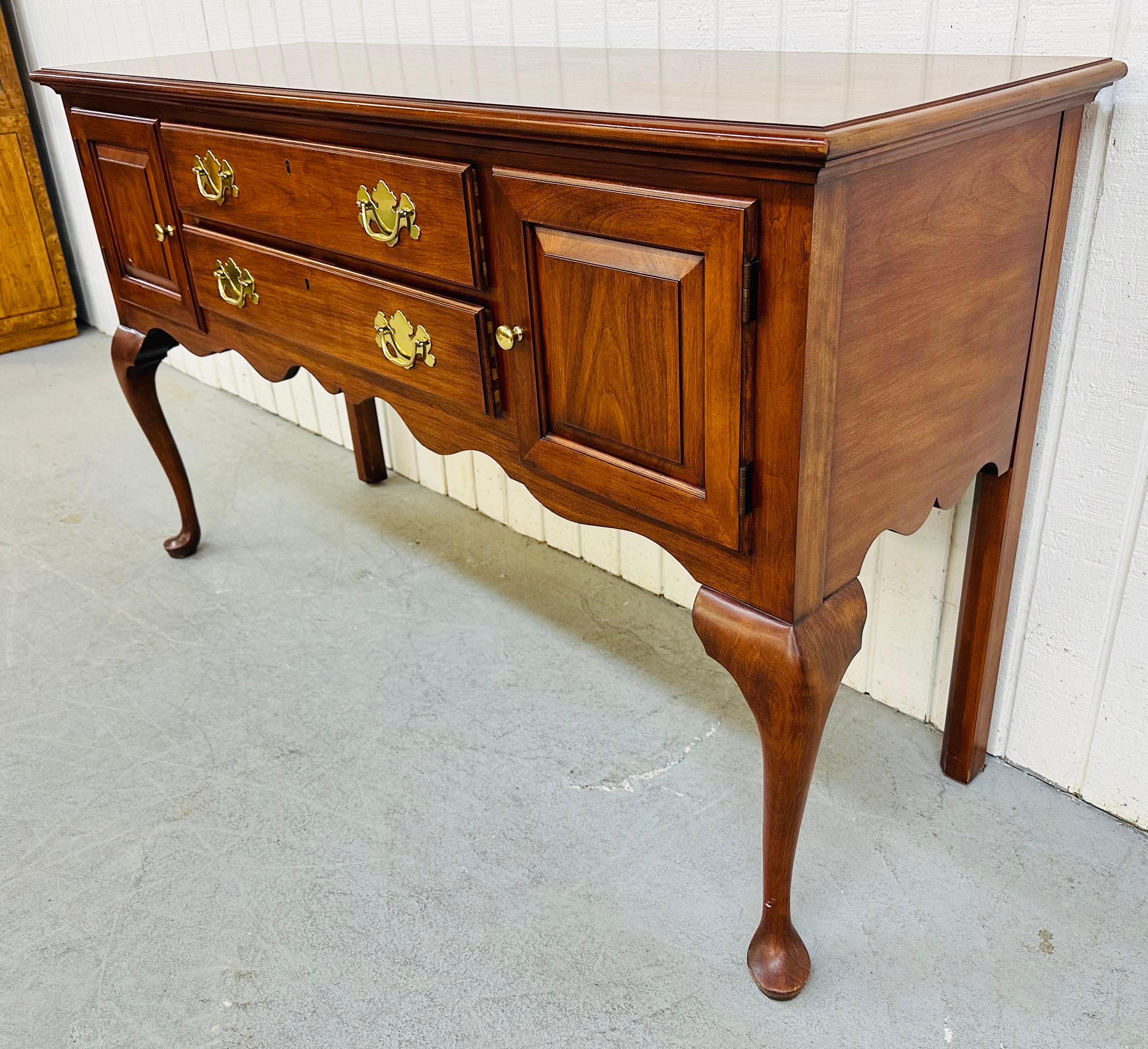 This listing is for a 1993 Henkel Harris Cherry Buffet. Featuring a rectangular top, two doors that open up to storage space, two drawers that pull open for silverware storage, a Queen Anne style leg, original brass hardware, and beautiful Cherry