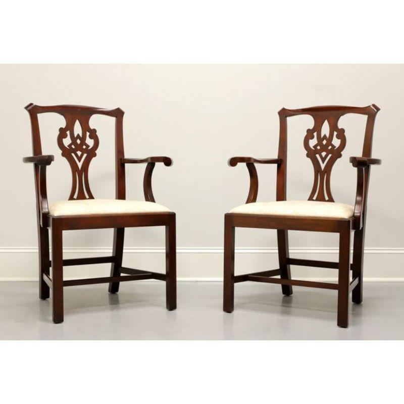 A pair of Chippendale style dining armchairs by Henkel Harris of Winchester, Virginia, USA. Solid Mahogany with carved seatbacks, straight legs and fabric upholstered seat. Made circa 1994. Style #: 101A, Finish: 29

Measures:  Overall: 25.25W 22D