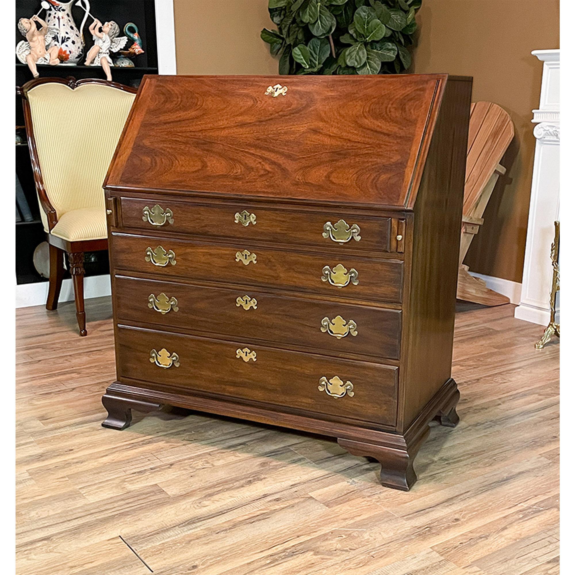 A Vintage Henkel Harris Secretary Desk. This desk is impressive in both it’s design and scale. Made of beautifully grained solid mahogany, the bookcase features a wide range of shelves and storage areas in the interior of the cabinet. The top
