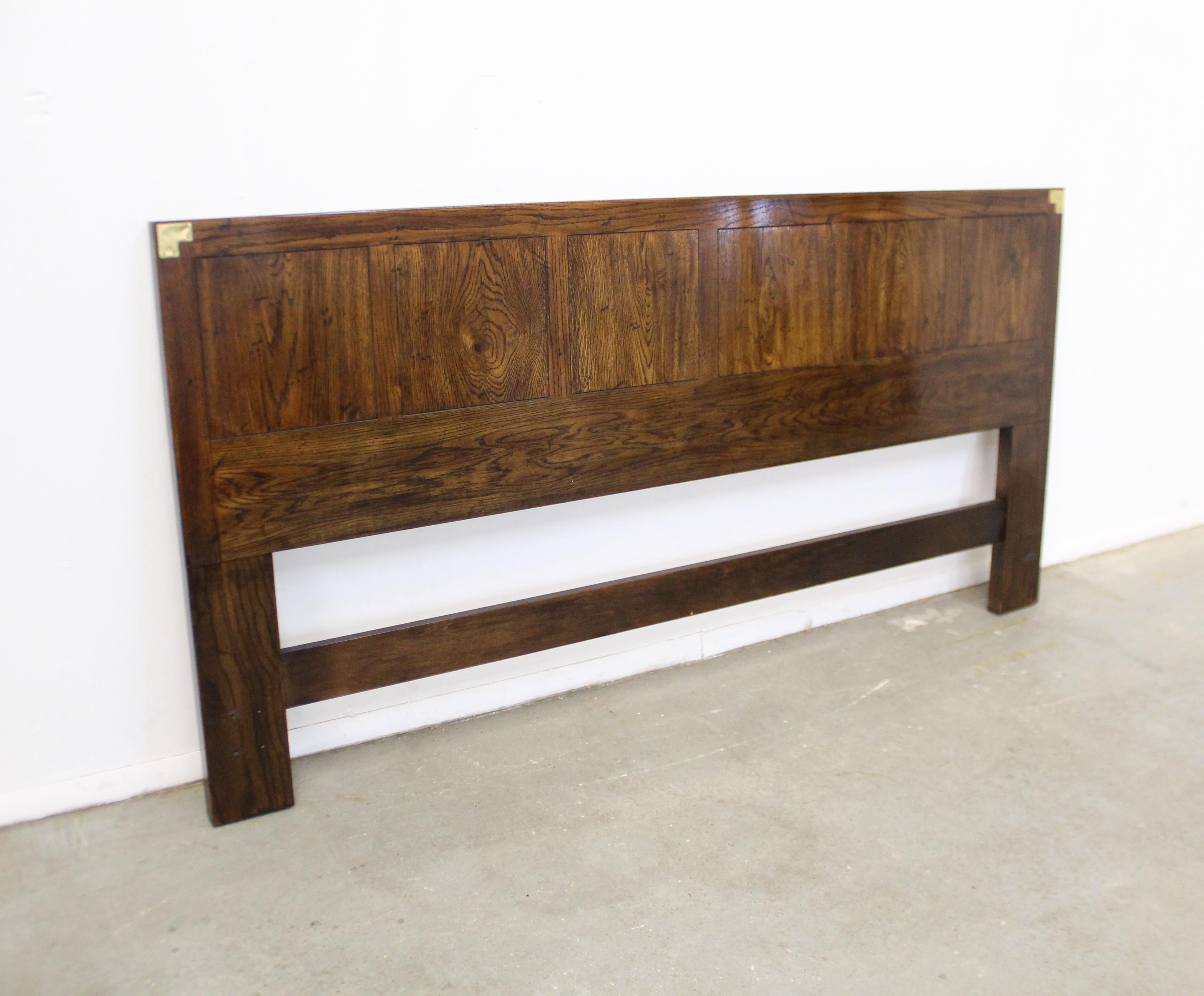 Offered is a vintage Campaign style king size headboard made by Henredon. It is made of what looks to be solid wood and has brass accents on the top corners. It is in good condition, shows slight surface scratches and chips (see photos). It is