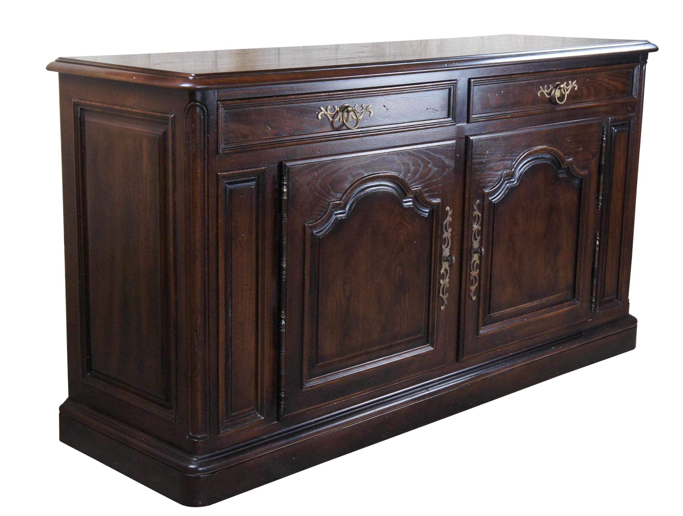 Henredon Four Centuries collection Country French bar cabinet or server, circa 1970s. features a rectangular frame made from oak with two large dovetailed drawers over a lower cabinet with shelf.  Includes paneled accents and ornate scrolled brass