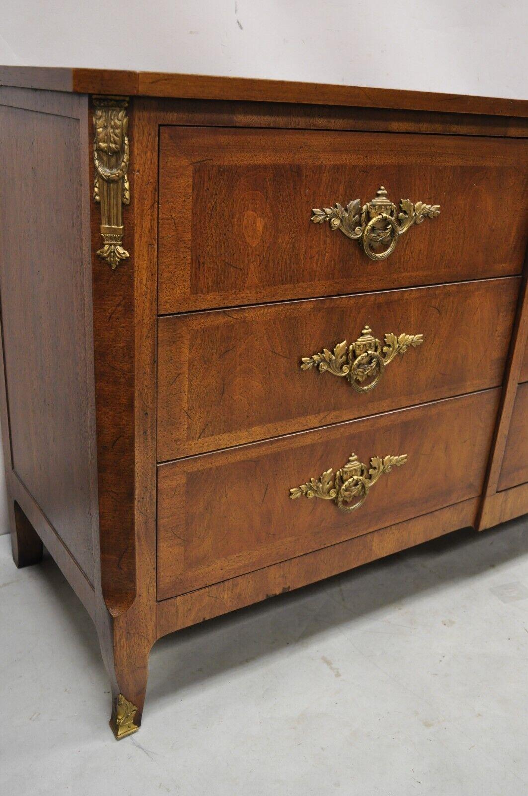 Vintage Henredon French Louis XV style walnut 9 drawer triple dresser. Item features ornate brass ormolu, leafy scroll and urn brass back plates, brass capped front legs, banded drawer fronts and top, beautiful wood grain, original stamp, 9