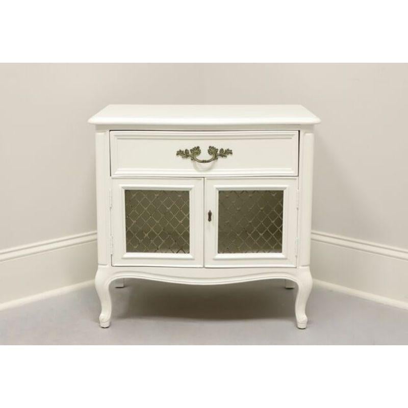A French Provincial style nightstand by Henredon. Freshly painted a neutral color with solid wood frame and brass hardware. Features one dovetail drawer and lower cabinet with double brass mesh door fronts. Back of lower cabinet has hole for