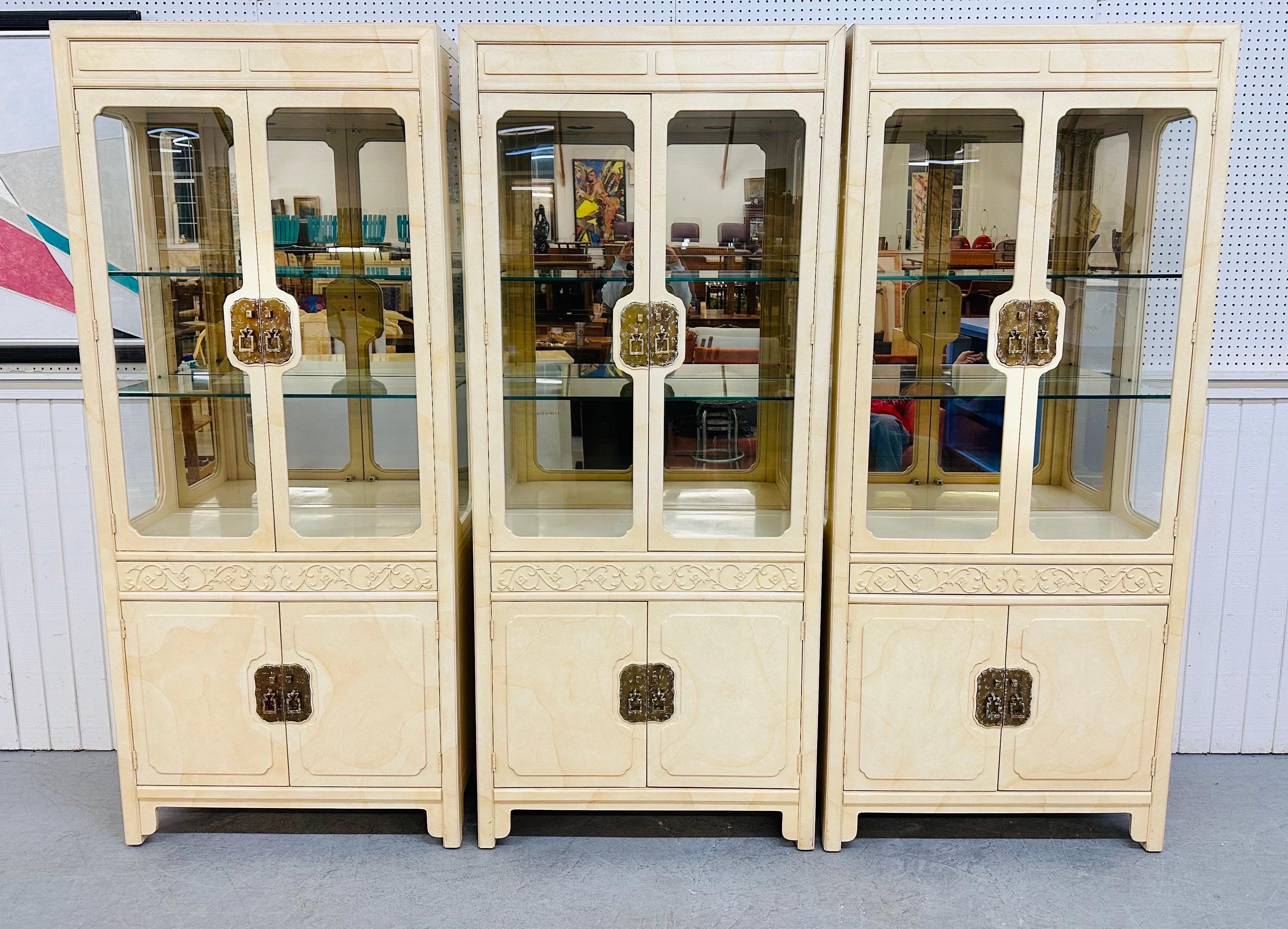 This listing is for a set of three vintage Asian inspired Henredon Lacquered Display Cabinets. Featuring two doors that open up to two glass shelves, a mirrored back, one hidden drawer that pushes open, two doors at the bottom that opens up to a
