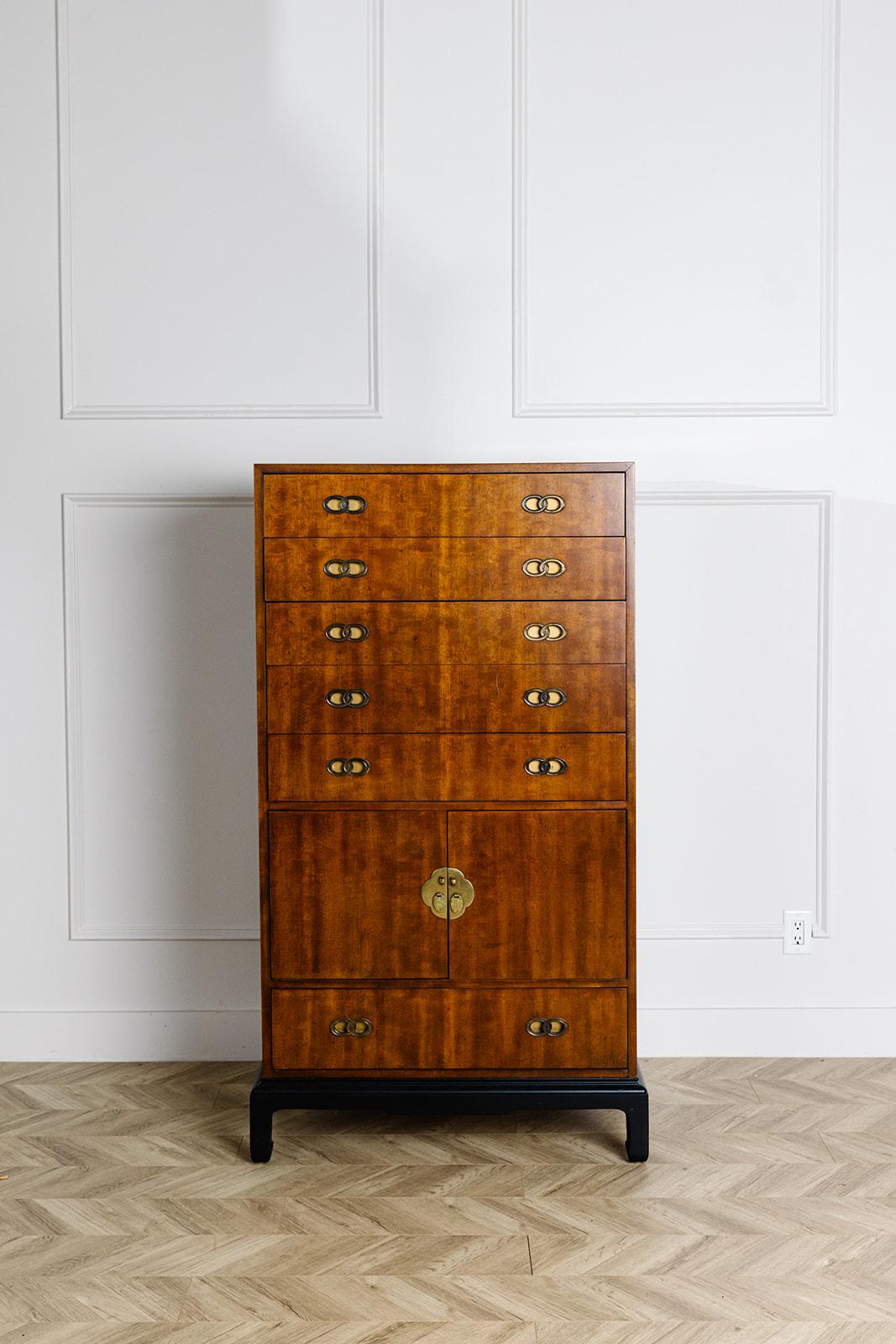 This vintage mahogany campaign style armoire by Henredon has been professionally refinished with a new satin clear coat. Built from a stunning flame mahogany, it features 6 drawers and 1 cabinet with vertical wood organizers in place. The beautiful