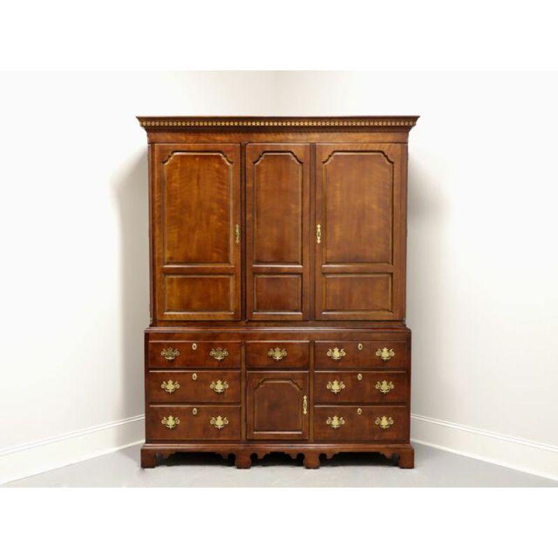 A large Chippendale style armoire by Henredon, from their Salem Collection. Cherry wood, brass hardware, crown molding with dentils and ogee bracket feet. Upper area with three solid fold open doors. Left side door revealing two adjustable wood