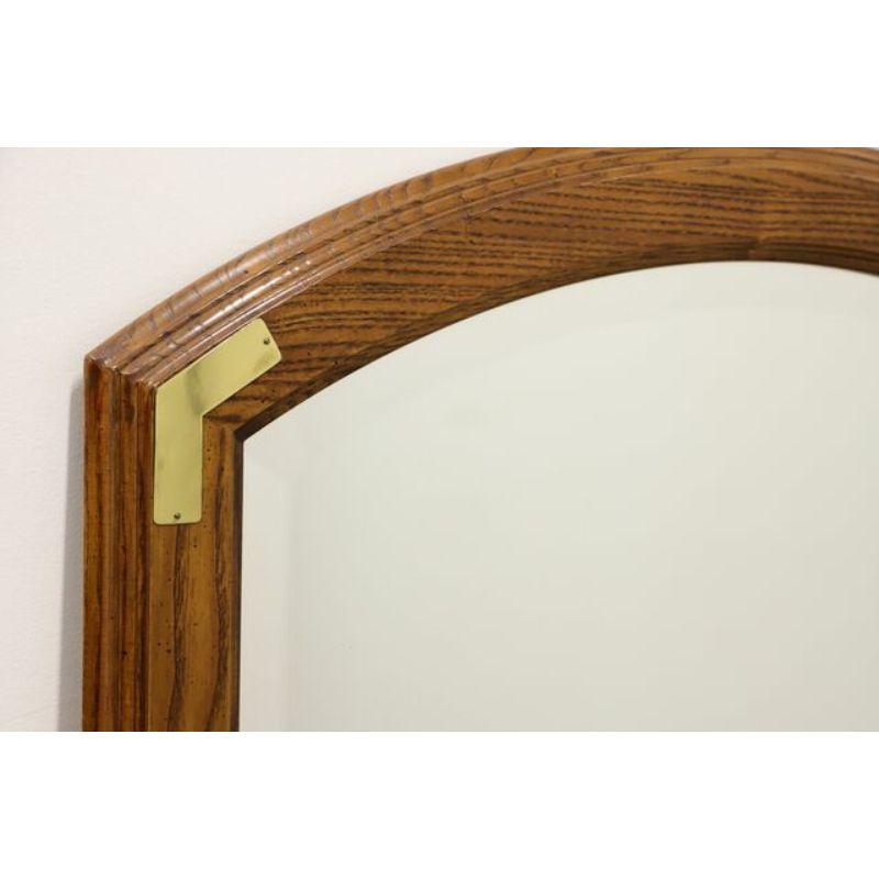 A campaign style wall mirror by Henredon, from their Scene One collection. Beveled mirror glass and arched top fruitwood frame with brass accents. Made in North Carolina, USA, circa 1990's. 

Style #: 8210-04

Measures: 34 W 1.25 D 50 H, Weighs