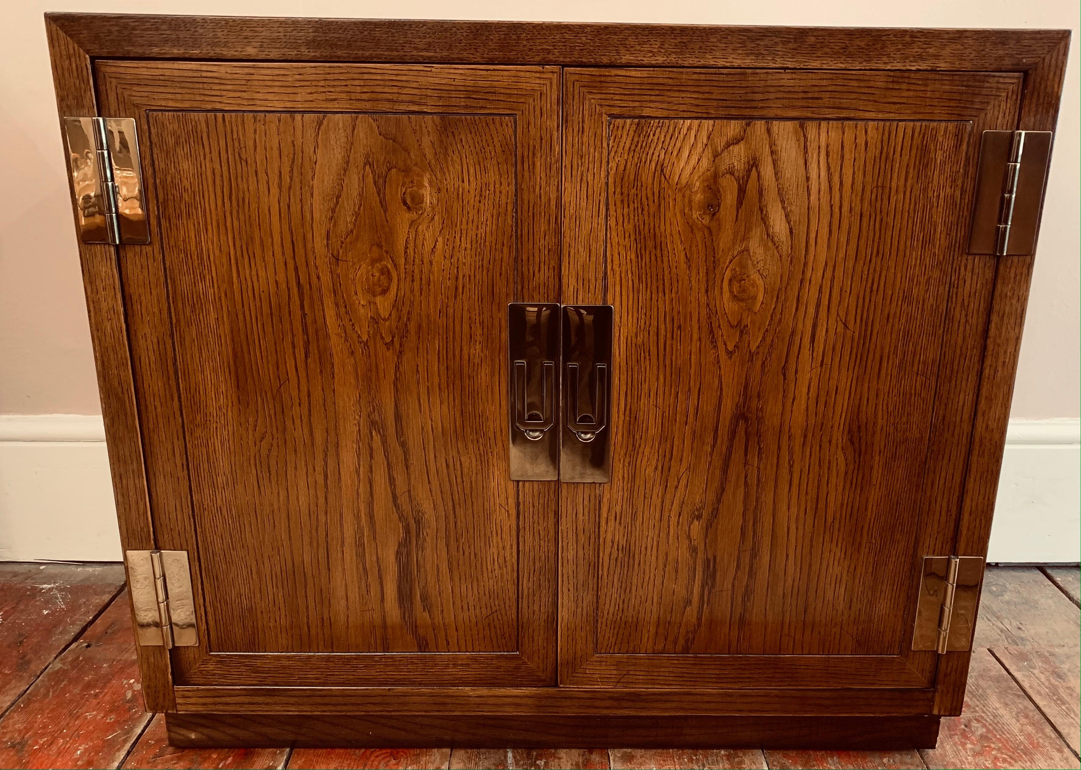 A vintage, 1970s, Henredon USA, Campaign two door cabinet. Hollywood Regency style. Made from stained Oak, with its original polished brass hardware pull handles and hinges. The chest is well made, solid and very heavy considering its size. The