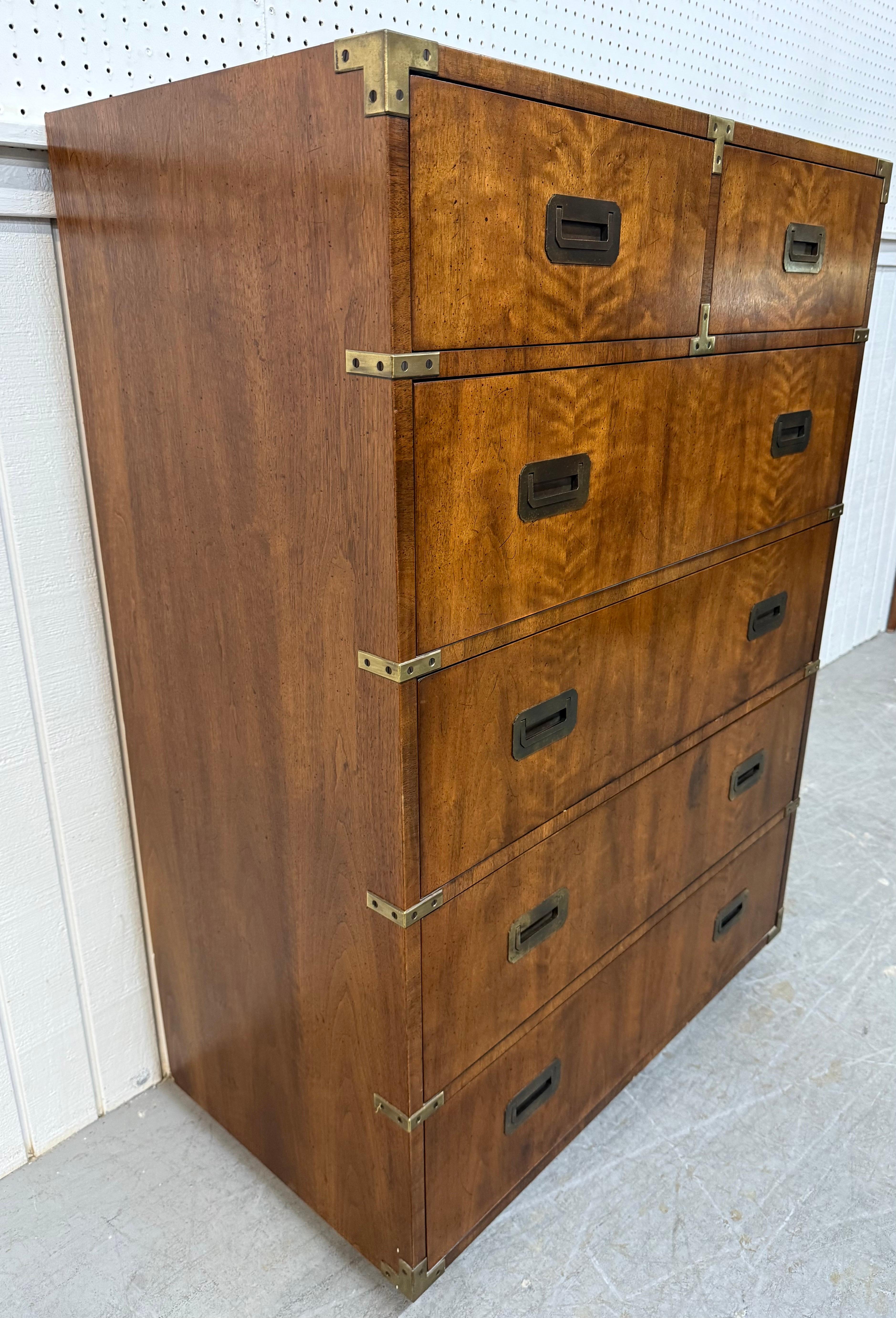 This listing is for a Vintage Henredon Walnut Campaign High Chest. Featuring a straight line design, five large drawers for storage, brass campaign pulls, brass accents, short cube feet, and an original walnut finish. This is an exceptional