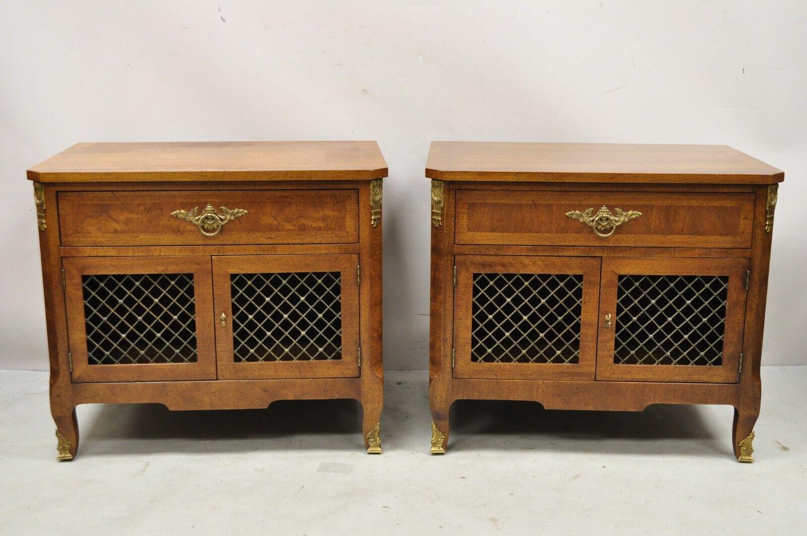 Vintage Henredon Walnut French Provincial Louis XV Style Nightstands - a Pair. Cette pièce présente des plateaux à bandes, du bronze doré, des façades de portes en treillis en laiton, 2 portes battantes, cachet d'origine, 1 tiroir à queue d'aronde,