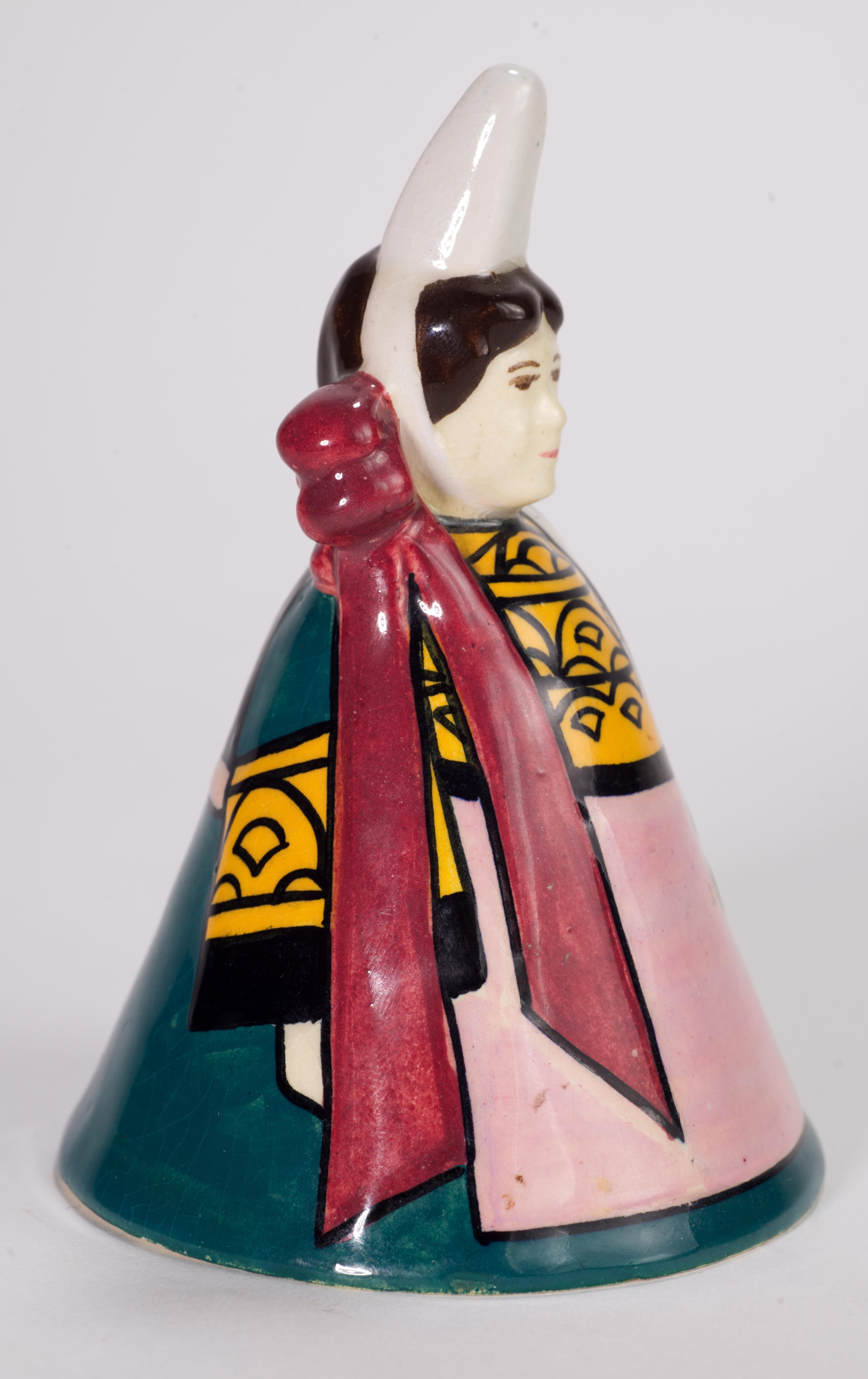  Rare figurine de fille en faïence de Henriot Quimper qui peut être utilisée comme une cloche. Elle est peinte à la main avec une tenue traditionnelle de style campagnard et une grande coiffe. La palette de couleurs vert forêt, jaune d'œuf, rose