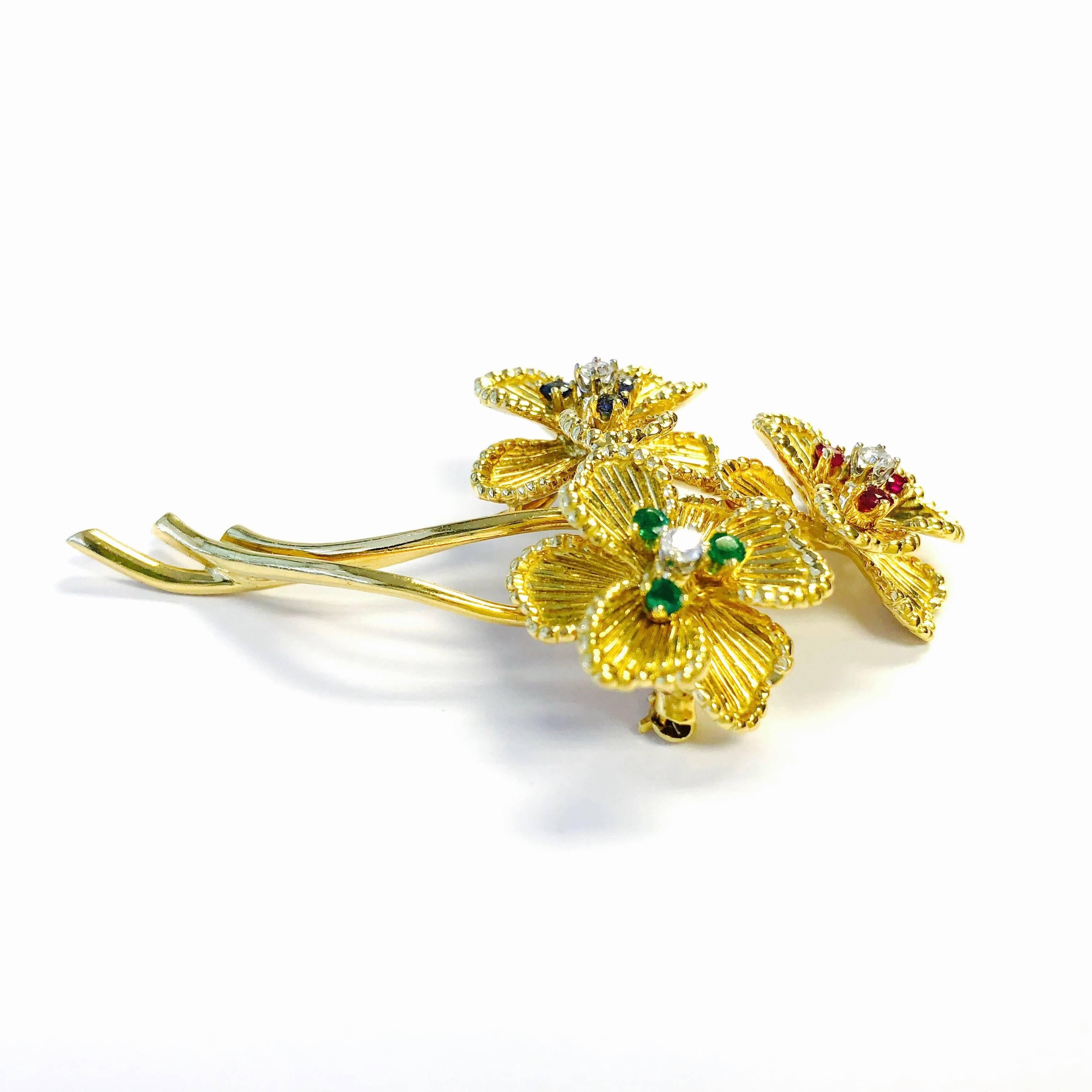 Crafted in 18k yellow gold, featuring 4-stone clusters of diamonds (color: F-G, clarity: VS), emeralds, sapphires and rubies in a triple flower design. 
Marked: 