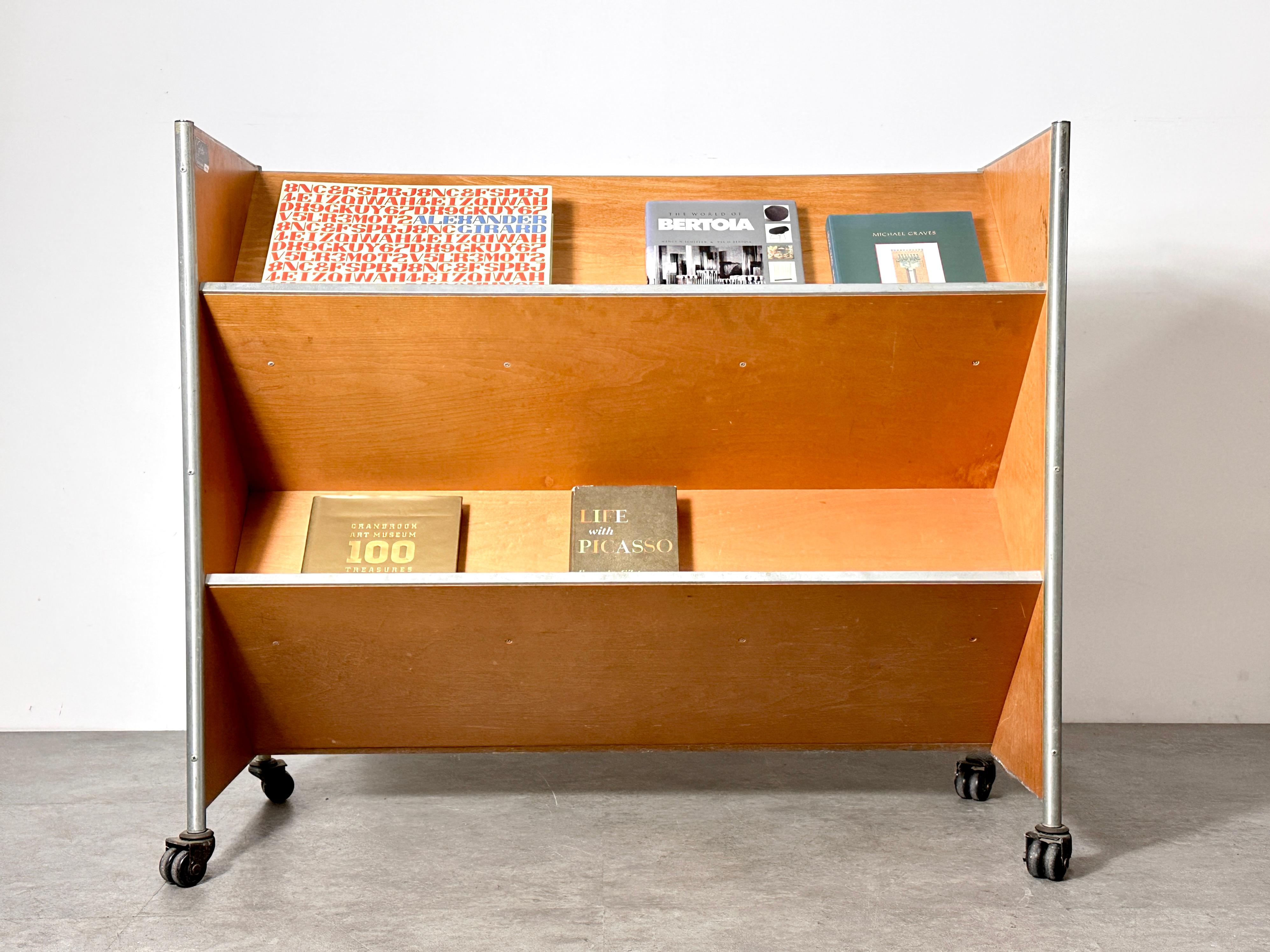 Industrial book truck designed by Henry P Glass for Fleetwood circa 1950s
Architectural design features dual sided slanted shelving in birch with a tubular steel frame
Original label intact
