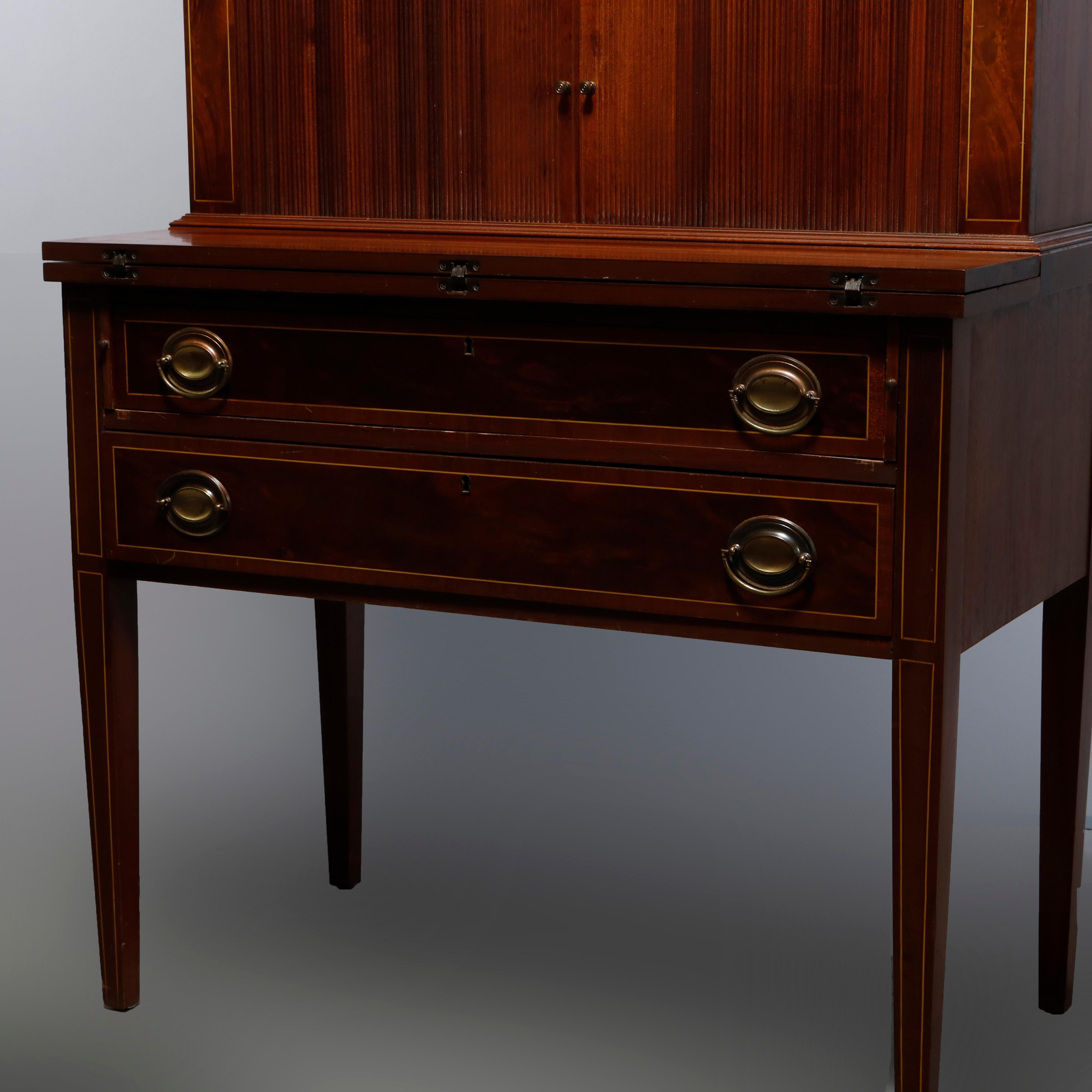 A vintage Hepplewhite style secretary by Maddox offers mahogany construction with upper bookcase having double mullioned glass doors over case with tambour doors opening to storage flanked by satinwood inlaid supports and surmounting drop front desk