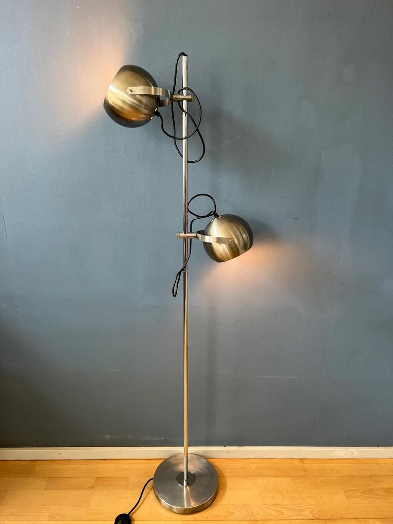 A classic eyeball floorlamp produced by the Dutch Herda from stainless steel. The design allows you to position the eyeball shades in any way desirable in the metal rings. The lamp requires two E27 lightbulbs and currently has a EU-plug.

Additional