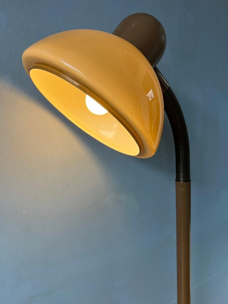 Lampadaire de l'ère spatiale Herda marron avec abat-jour champignon en plexiglas. L'abat-jour en forme de champignon beige/brun peut être facilement ajusté de sa position grâce à son bras flexible. La lampe nécessite une ampoule E27/26 et dispose