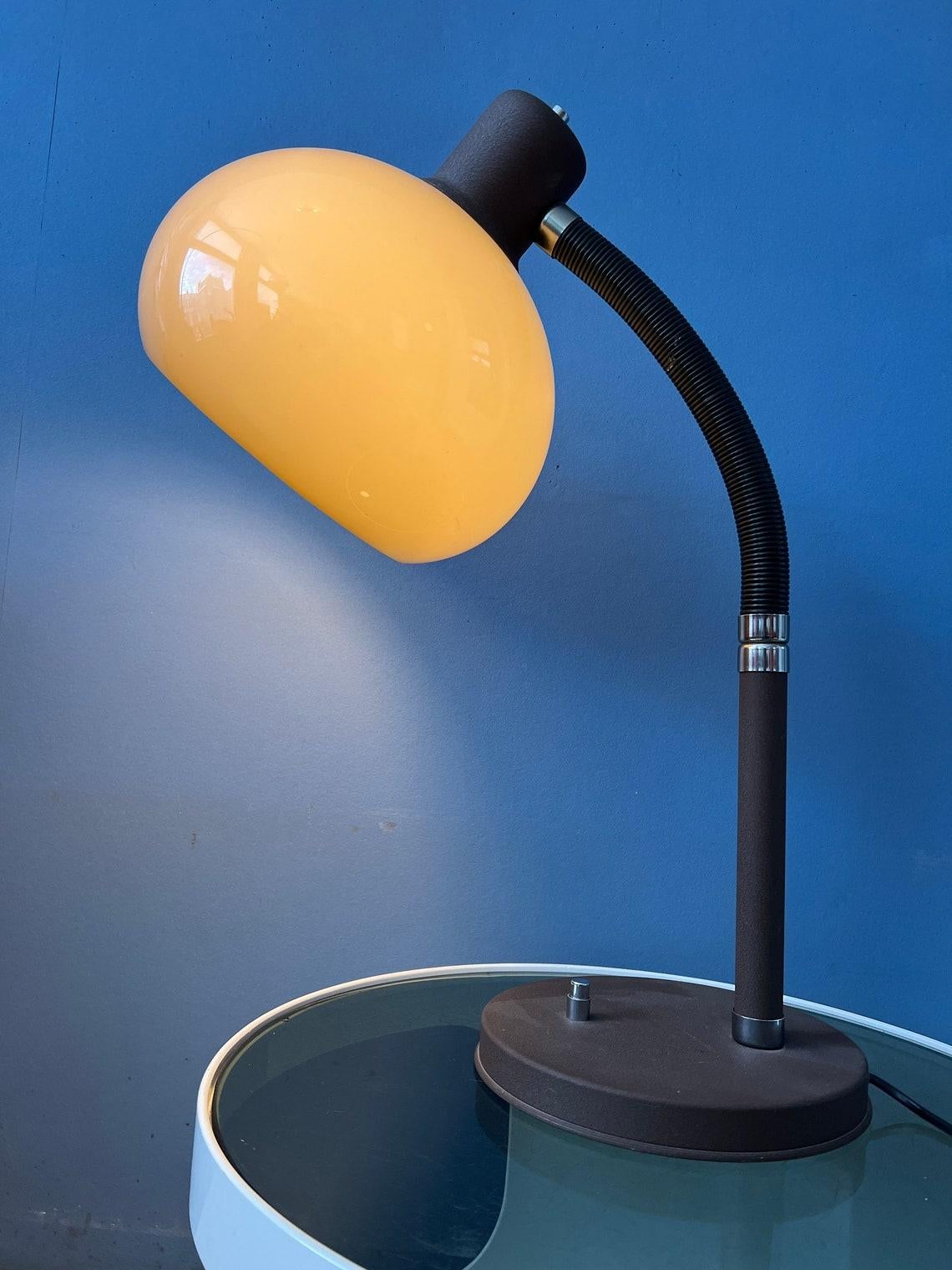 A very flexible mushroom table lamp by Herda. The acryllic mushroom shade produces a warm light. This model has a flexible, movable arm that can be turned in any direction. The switch is located on the base. The lamp requires an E27 lighting bulb