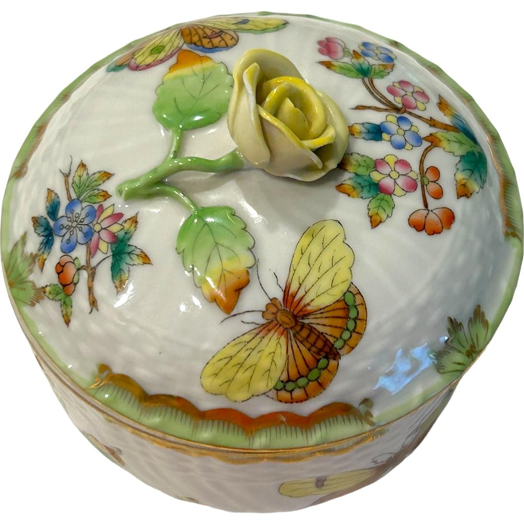 This vintage Herend sugar bowl is a beautiful addition to any collection.  The bowl features a floral and butterfly motif with a 3D yellow rose bud as the knob on lid.  Hand painted and accented in gold, this bowl is perfect for storing sugar or