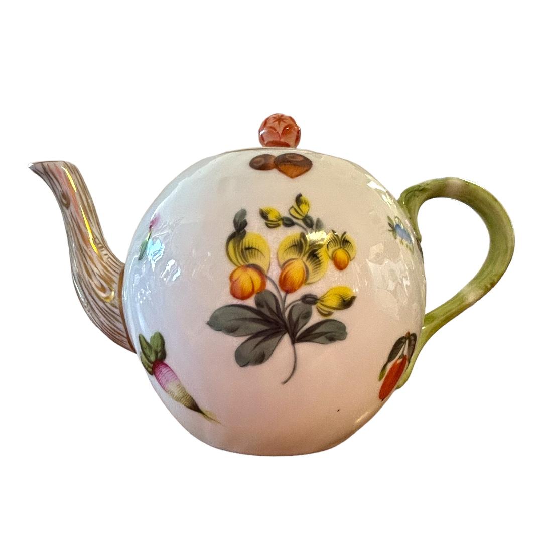 Traditional Herend botanical design grace this tea pot with its stylized “branch” spout and “vine” handle; the lid is topped by a coral colored rose; subtle swirl texture; a graceful addition to any tea table.