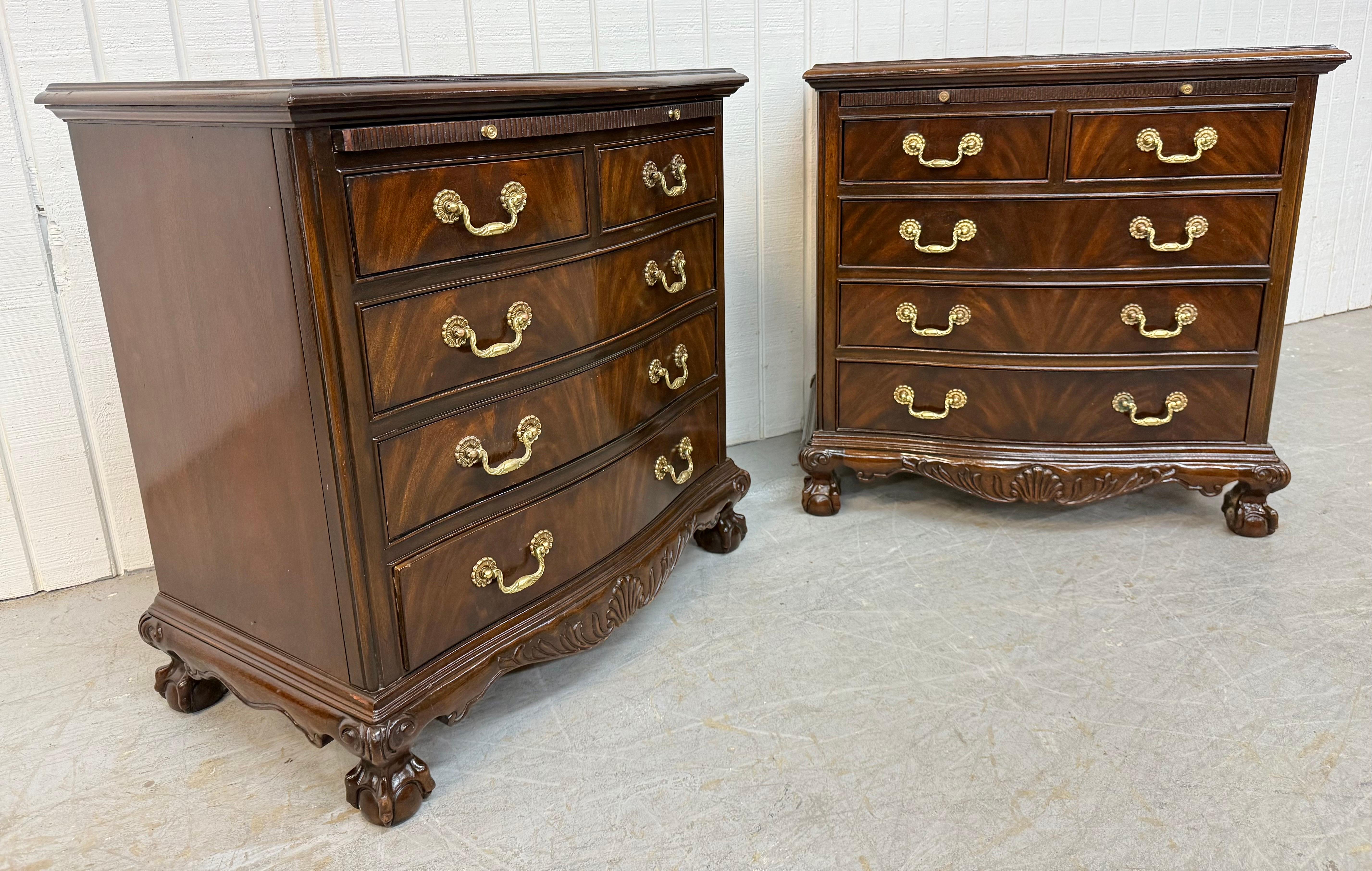 Cette annonce concerne une paire de tables de chevet de style Vintage Heritage en acajou. Elle présente un style traditionnel, un plateau extractible, cinq tiroirs de rangement, des poignées en laiton d'origine, une coquille sculptée, des pieds