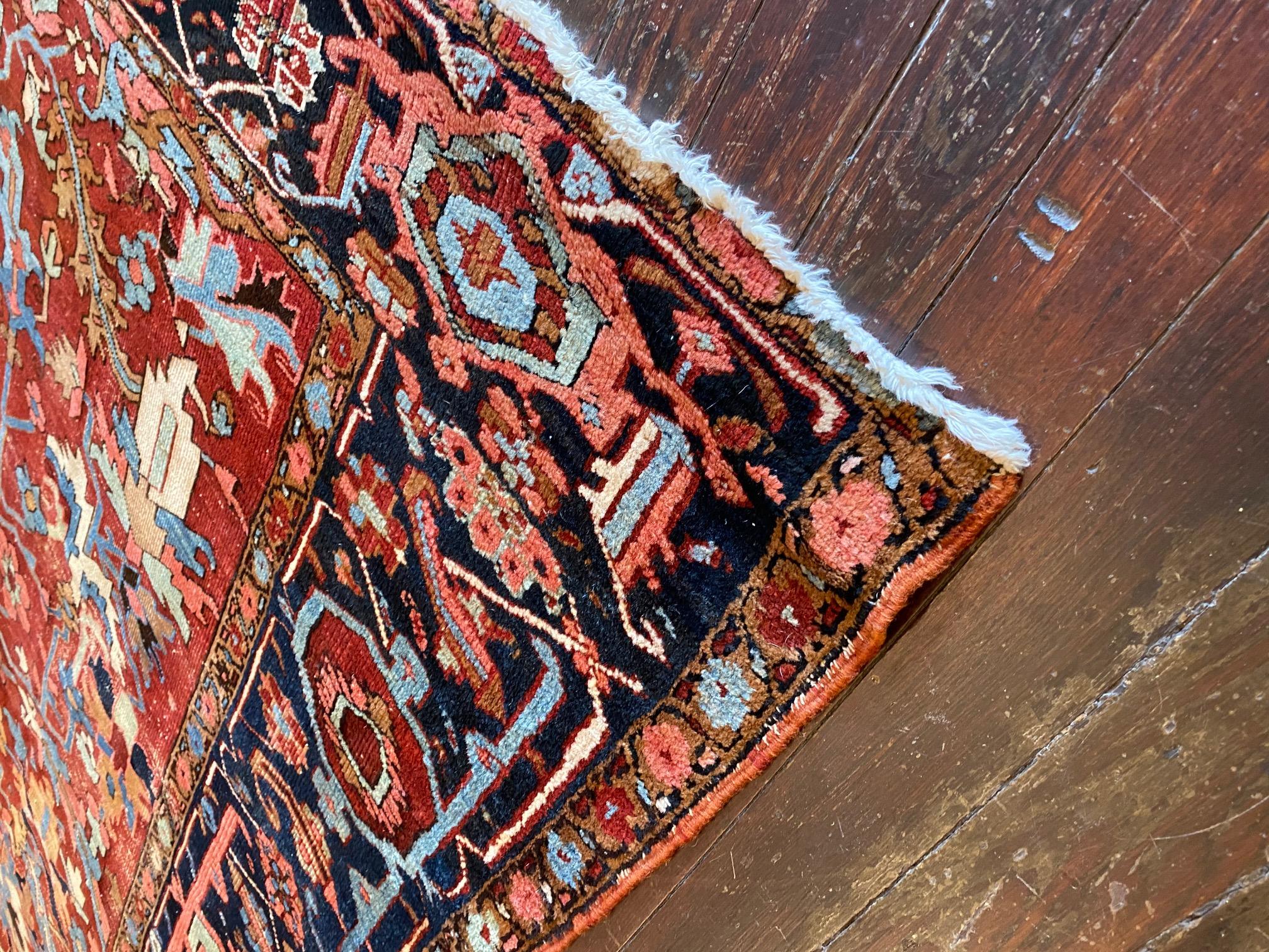 Step into a world of timeless beauty with the Early Twentieth Century Heriz Rug, a true treasure of Persian craftsmanship. This exceptional rug boasts beautiful classic tones of reds, blues, and golds, evoking a sense of opulence and grandeur. The