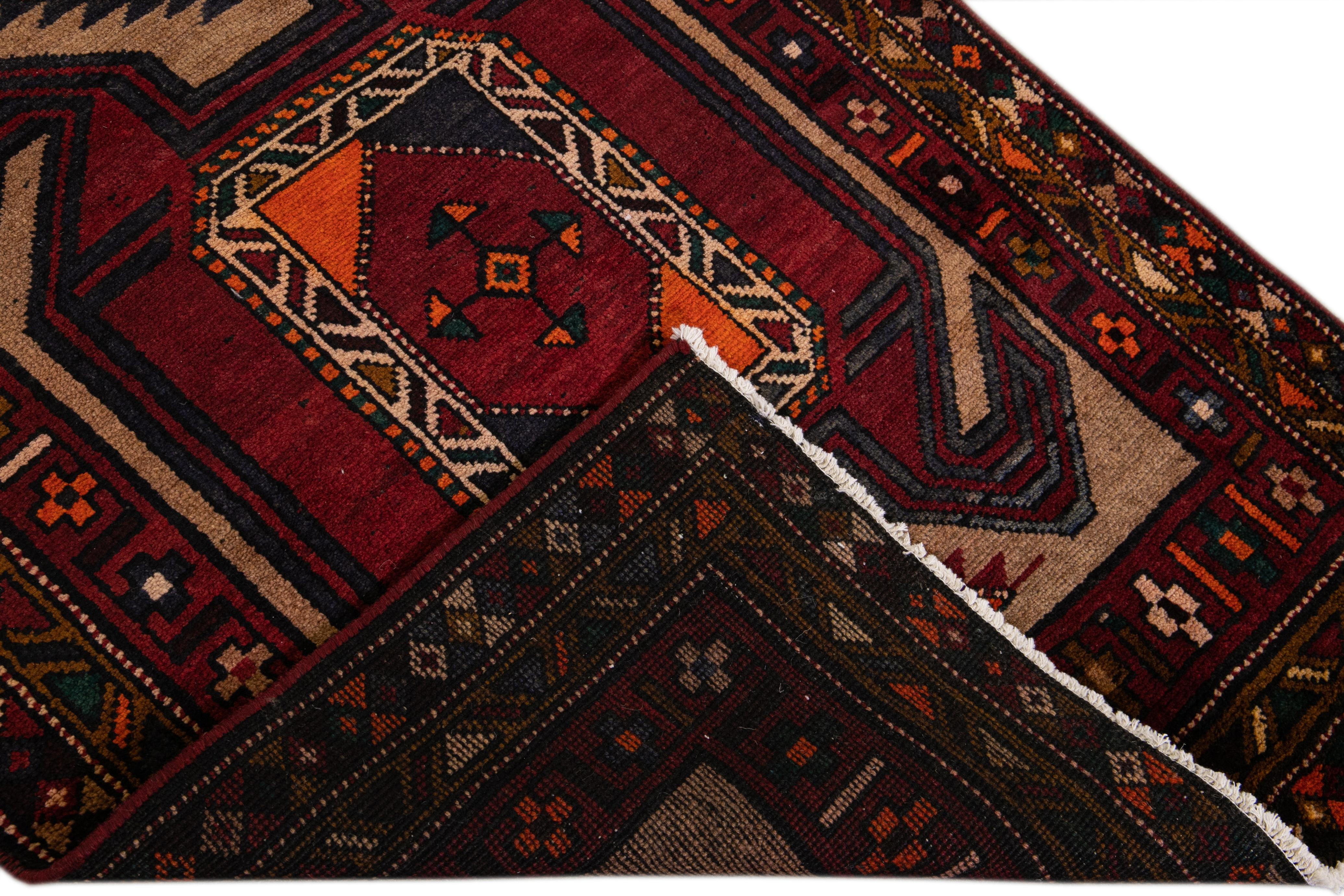 Beautiful vintage Heriz handmade wool runner with a brown field. This rug has red, orange, blue, and green accents in an all-over geometric design.

This rug measures: 3'6