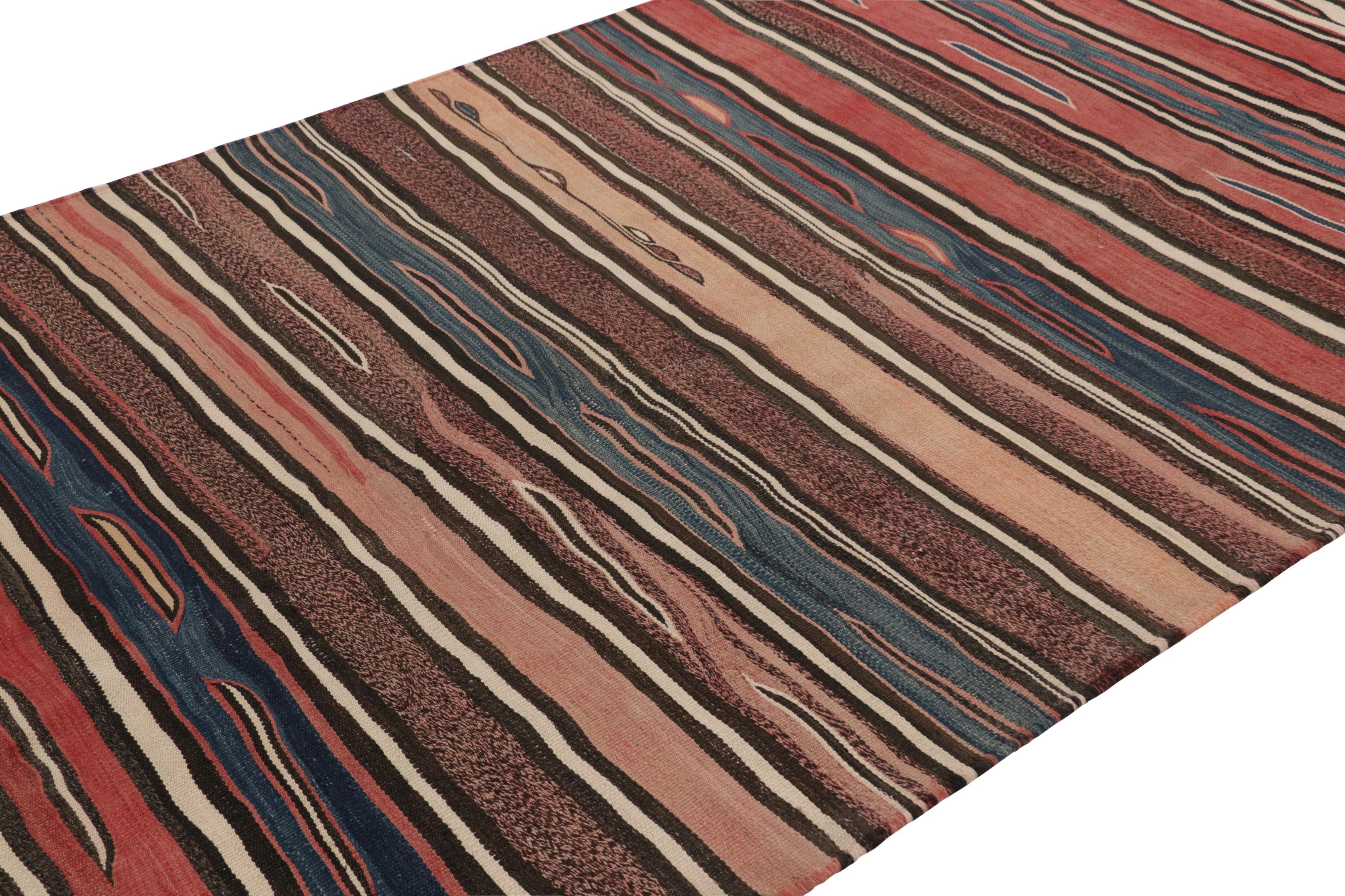 Fabricado con lana tejida a mano en Persia entre 1950 y 1960, este kilim Heriz vintage de 6x10 es una obra especialmente brillante y codiciada de una nueva y emocionante selección de la colección de kilims y tejidos planos clásicos de Rug &