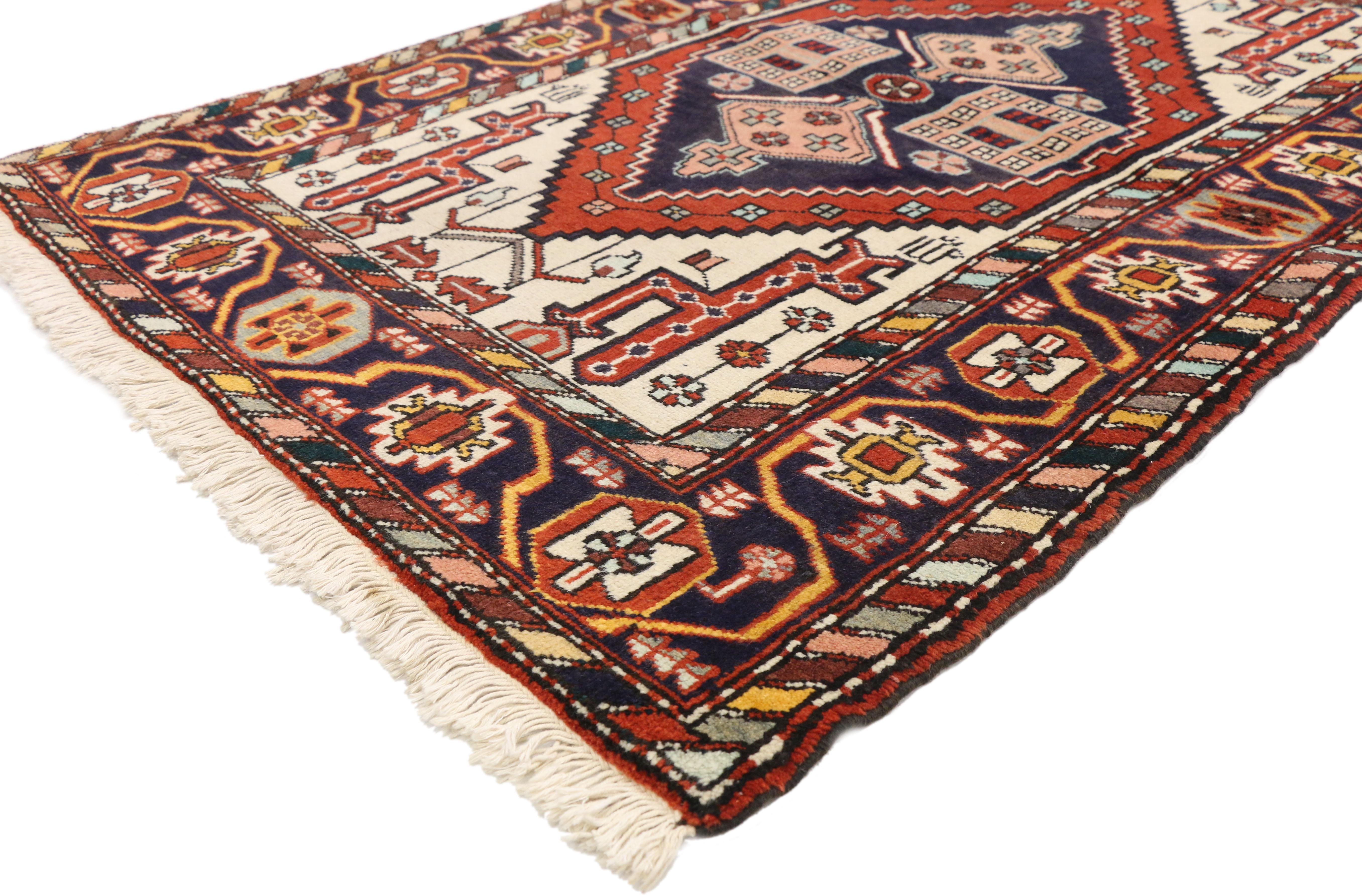 Full of character and stately presence, this vintage Heriz Persian rug with modern tribal style showcases an extravagant geometric design rendered in traditional colors of navy, red, blue and ivory-white with accents of pink, baby blue and apricot.