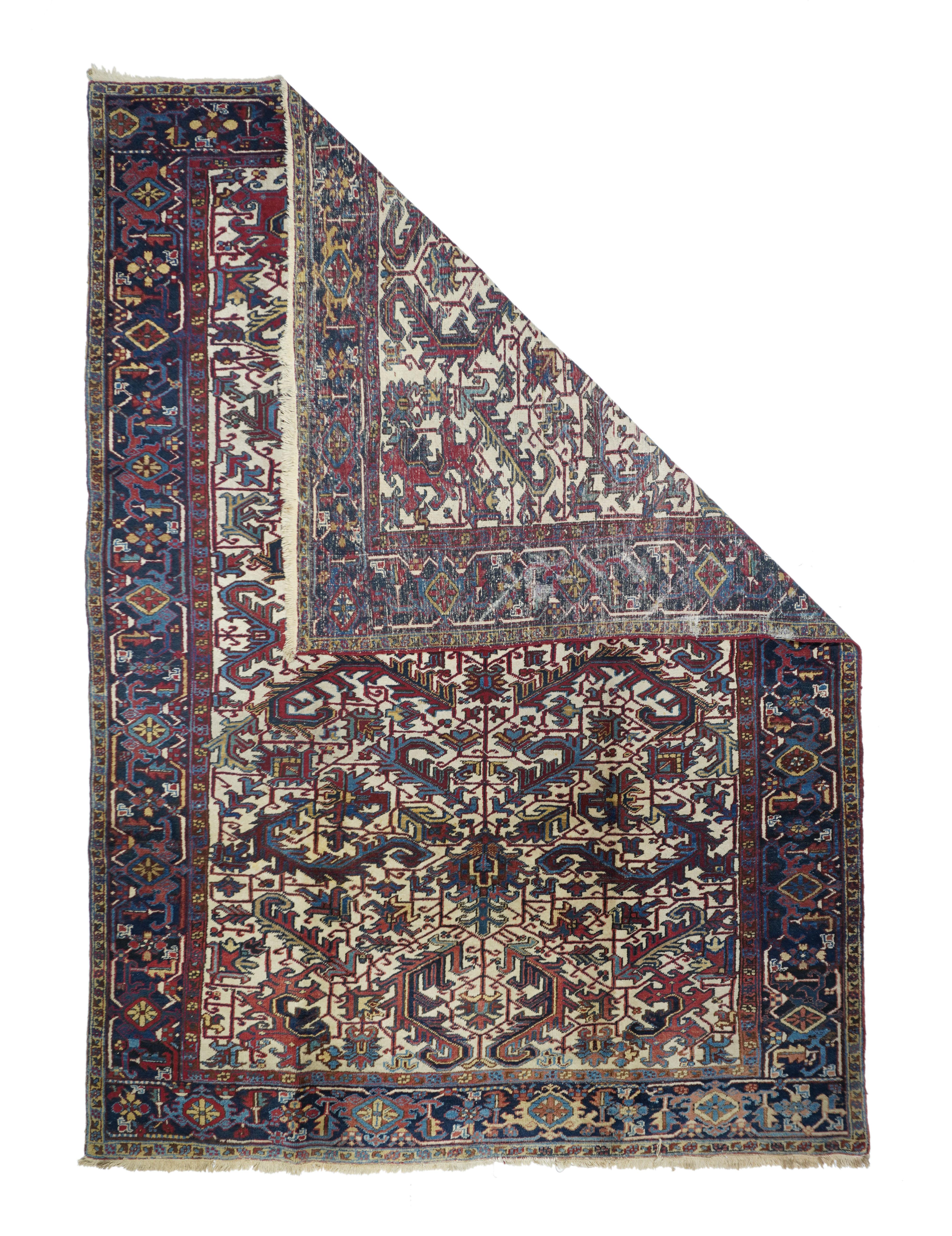 Vintage Heriz rug¬†7'4'' x 10'5''. The warm ecru ground shows a central axial pole, anchored by two petal palmettes, with pairs and singletons of large, volute, bent ragged bitonal leaves, right-angle vinery and supporting lesser palmettes. Navy