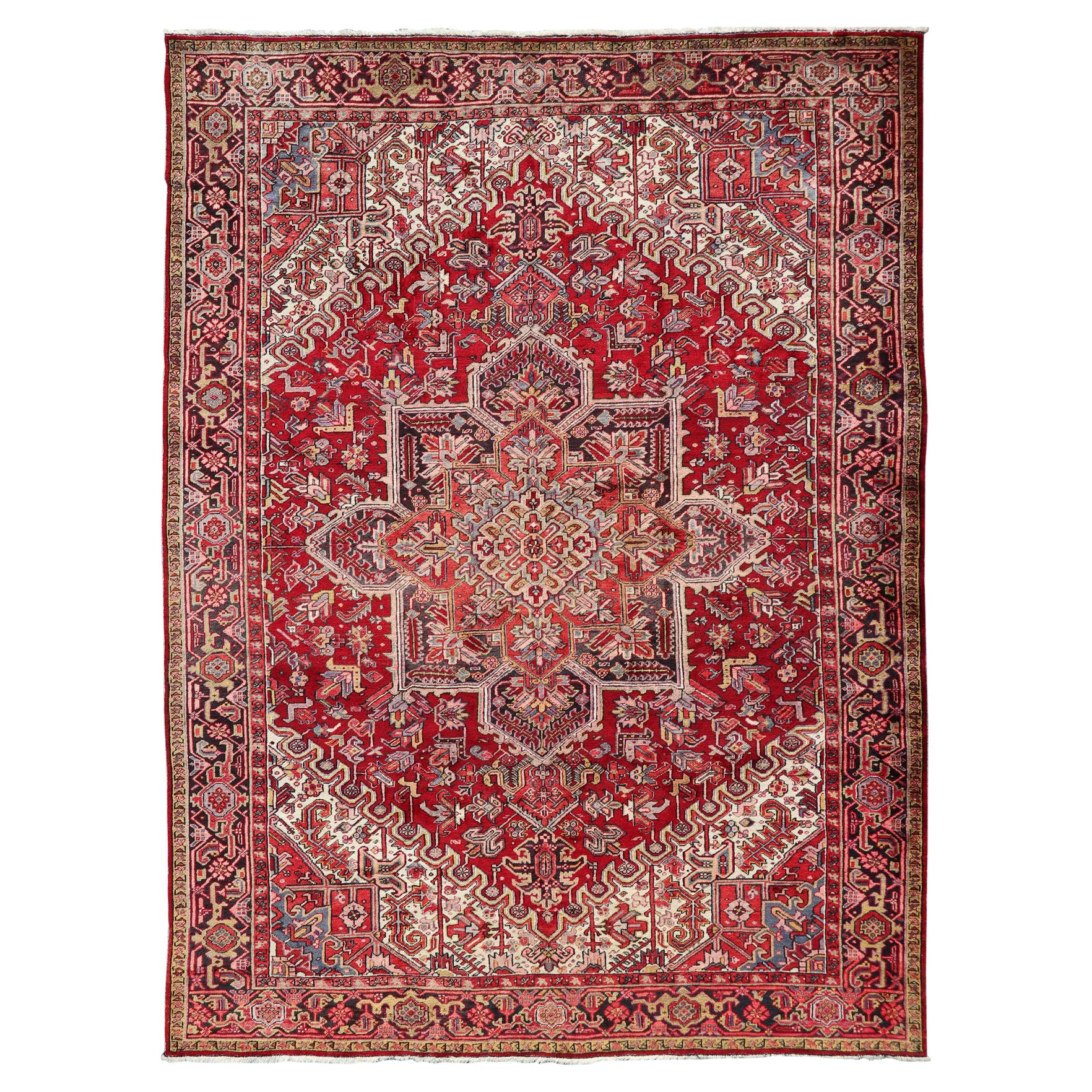 Heriz vintage con design geometrico a diamante nei colori rosso, avorio, blu e carbone.