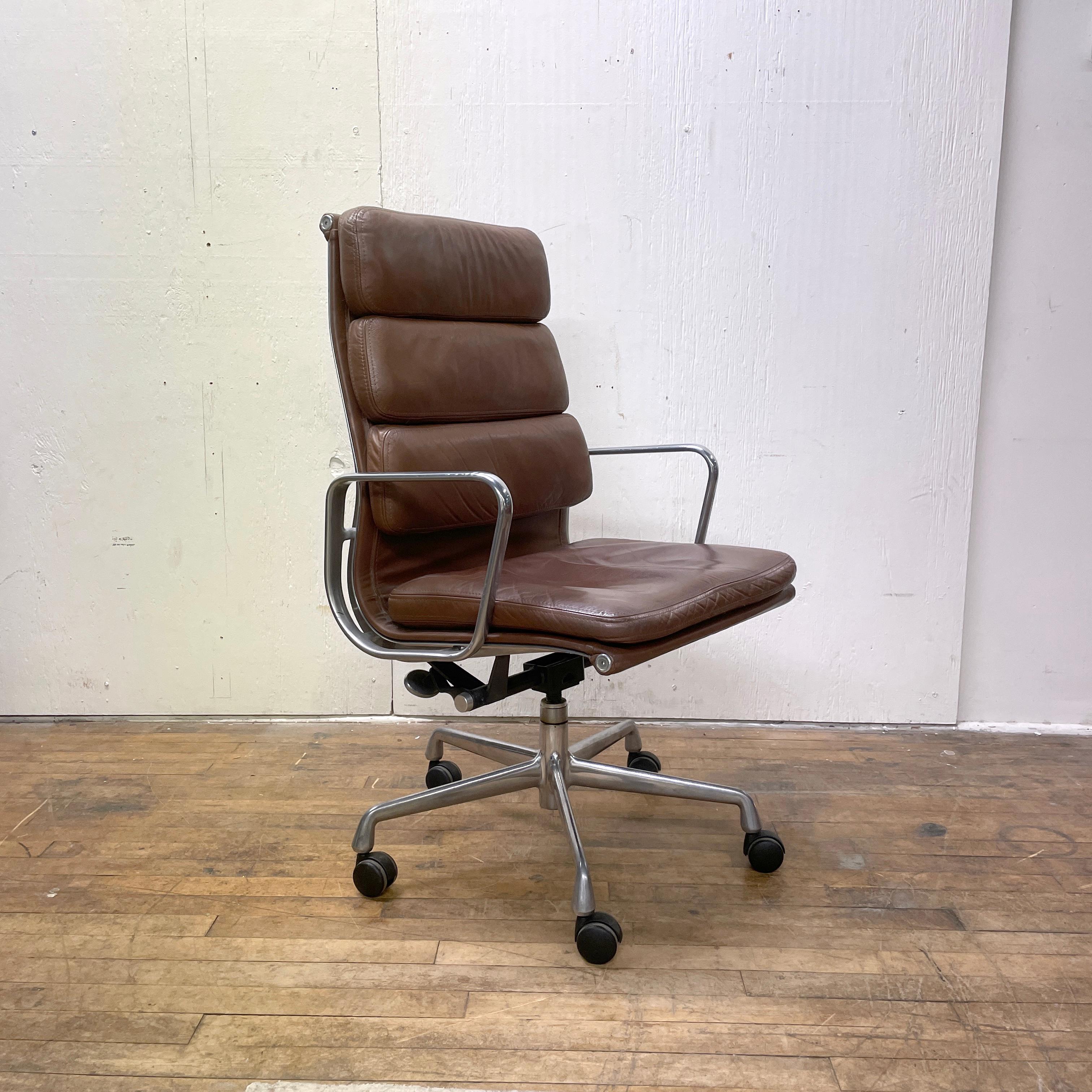 A super comfortable vintage softpad chair by Charles and Ray Eames for Herman Miller. The chair is upholstered in brown leather and has a five-star wheeled base. Rocks and swivels smoothly. The chair is in very good vintage condition with no rips or
