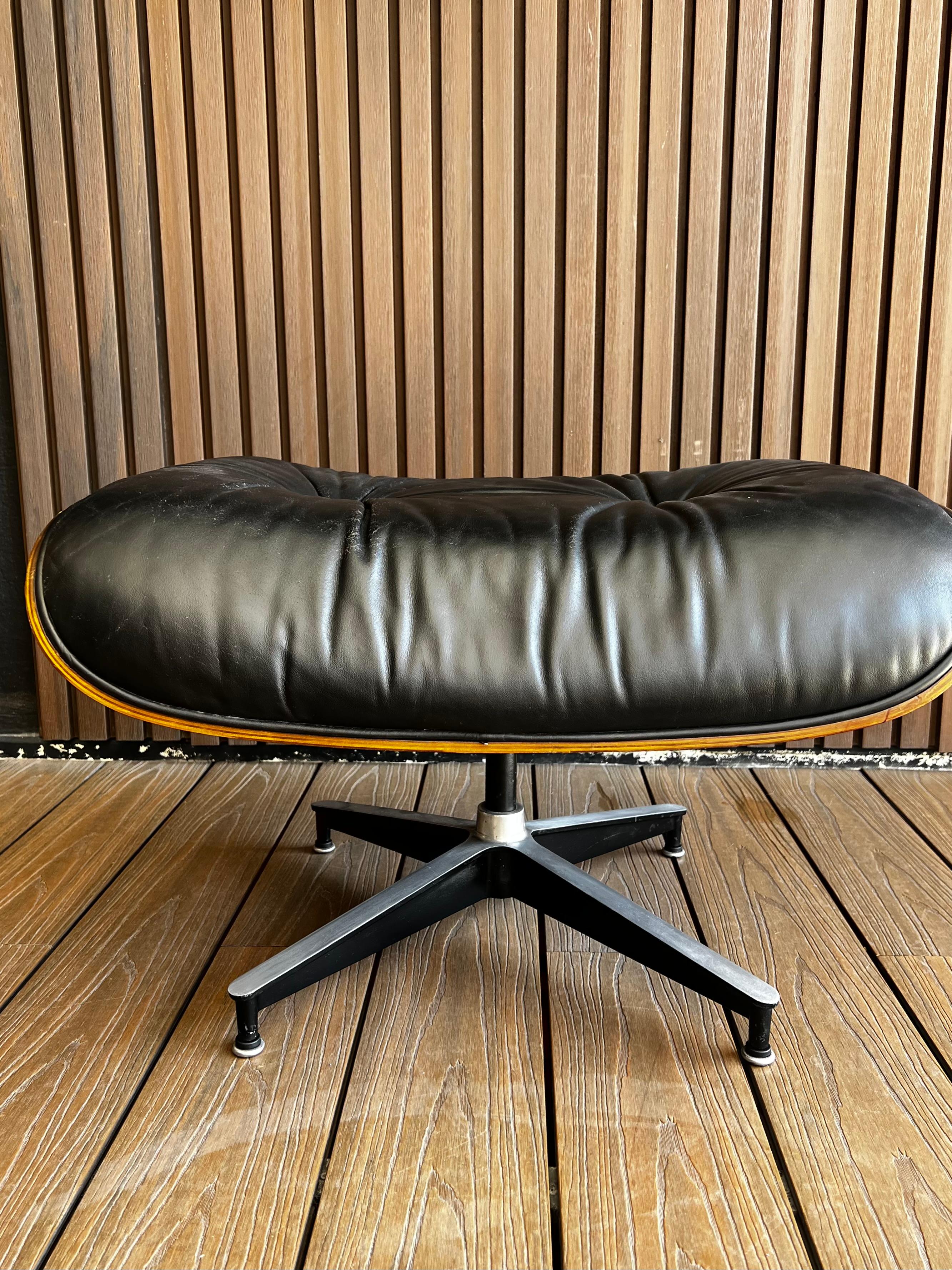 Pouf classique en palissandre et cuir noir conçu par Charles et Ray Eames par Herman Miller, circa 1969, état d'origine. 