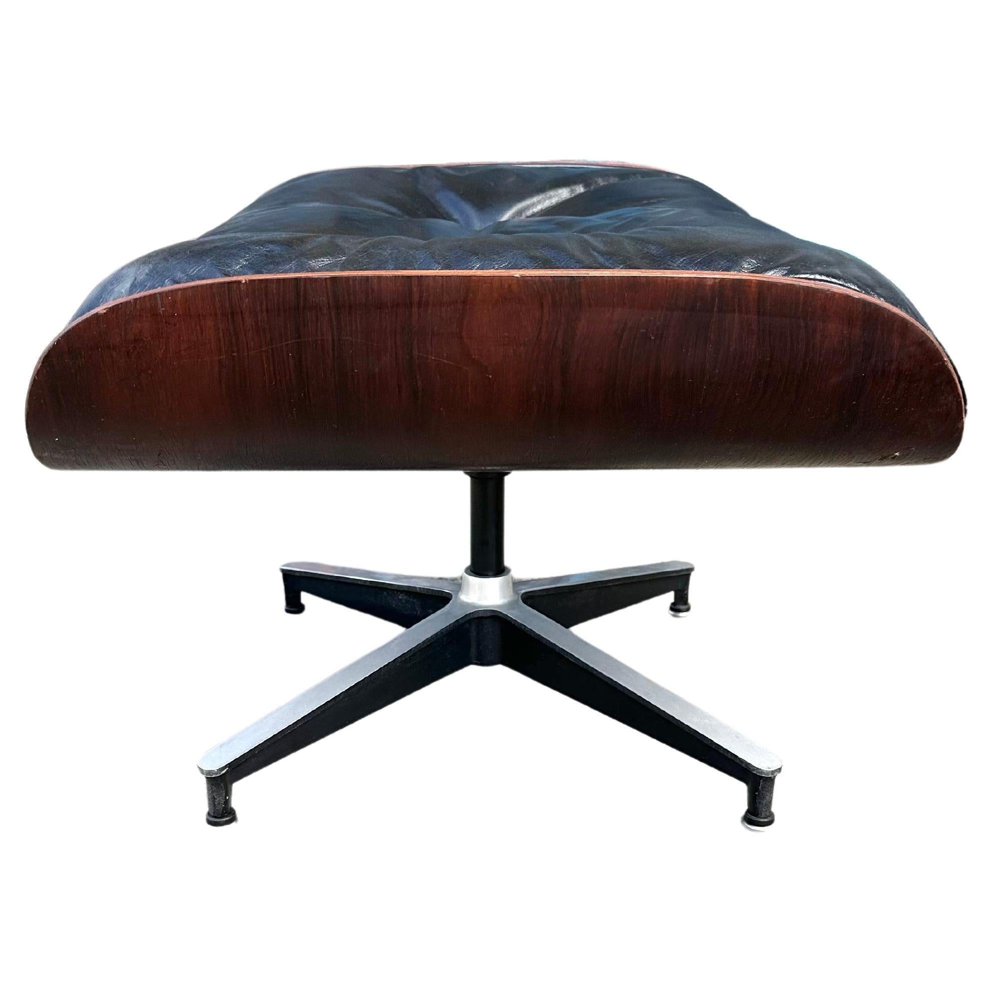 Hard to find single ottoman for the original Herman Miller lounge chair. Sale for ottoman only. Made from cast aluminum, black leather, and Brazilian rose wood. In good condition. All screws, buttons, and feet intact. Signed and guaranteed