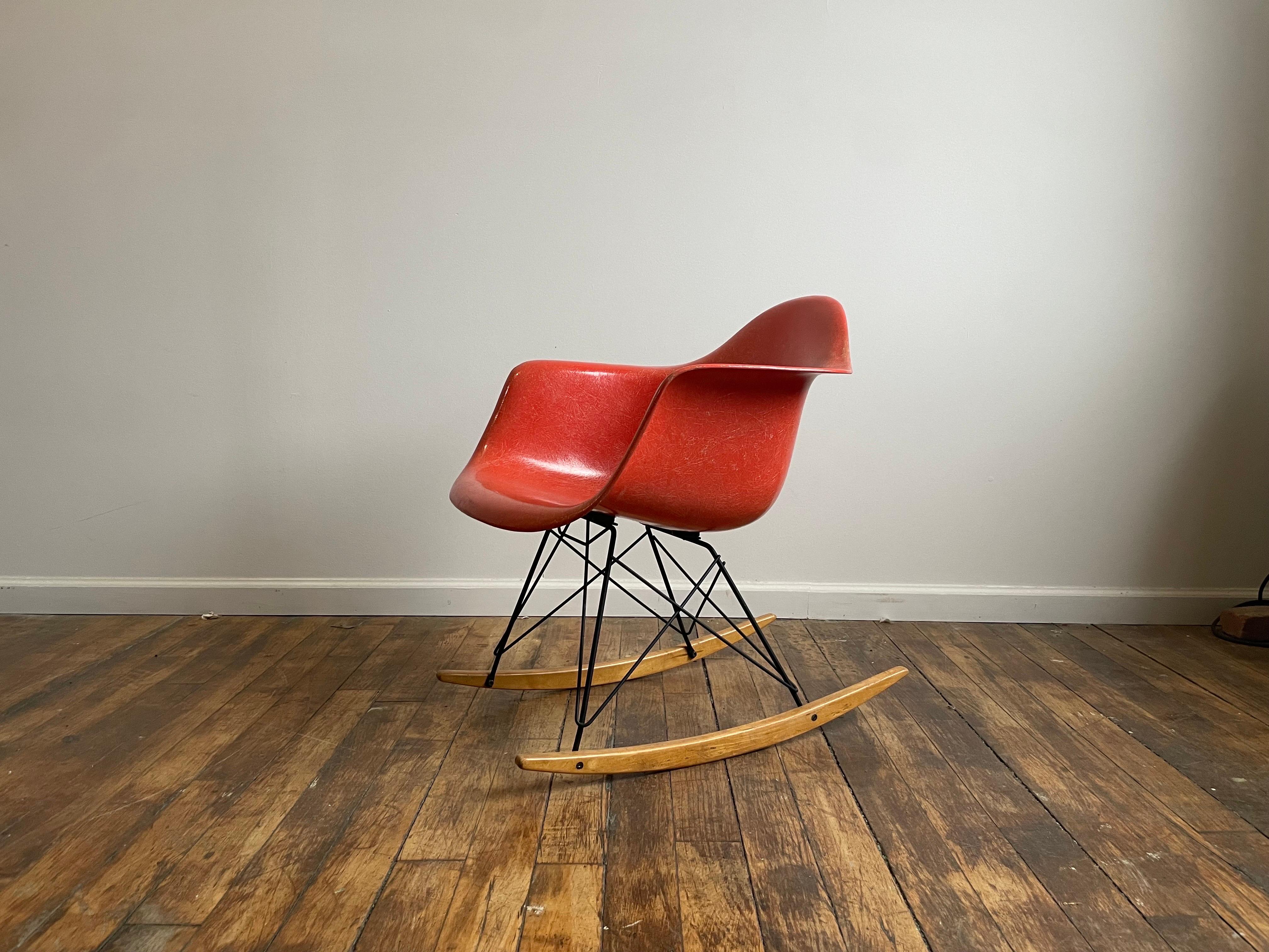 Excellent examples of vintage Eames rocker with oranger fiberglass. Remnants of sticker remain on the underside.

More history below:


The famous Eames Rocking (R) Arm (A) Chair on Rod (R) Base, abbreviated to RAR, was one of the ‘original 5’