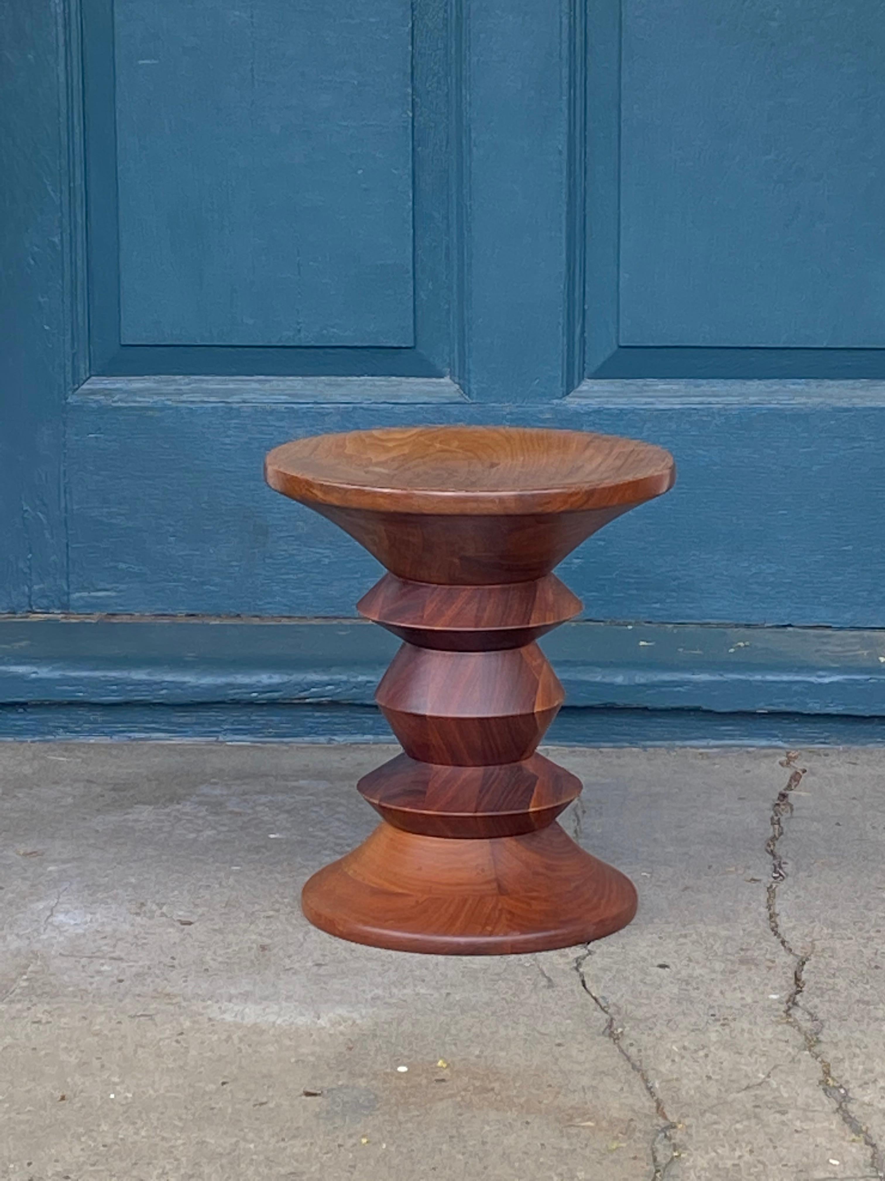 Classic Eames Time Life stool in turned walnut. Produced by Herman Miller. Vintage production. In good condition with normal wear.