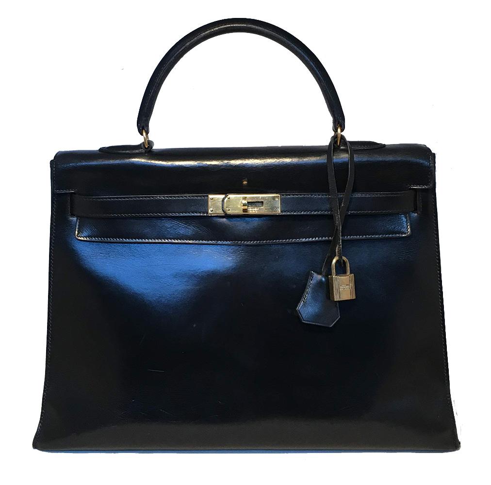 Vintage Hermes Black Box Calf Kelly 35 in fair condition. Smooth black box calf leather trimmed with gold hardware. Signature top flap turn lock double strap kelly style closure opens to a matching black leather lined interior that holds 3 side slit