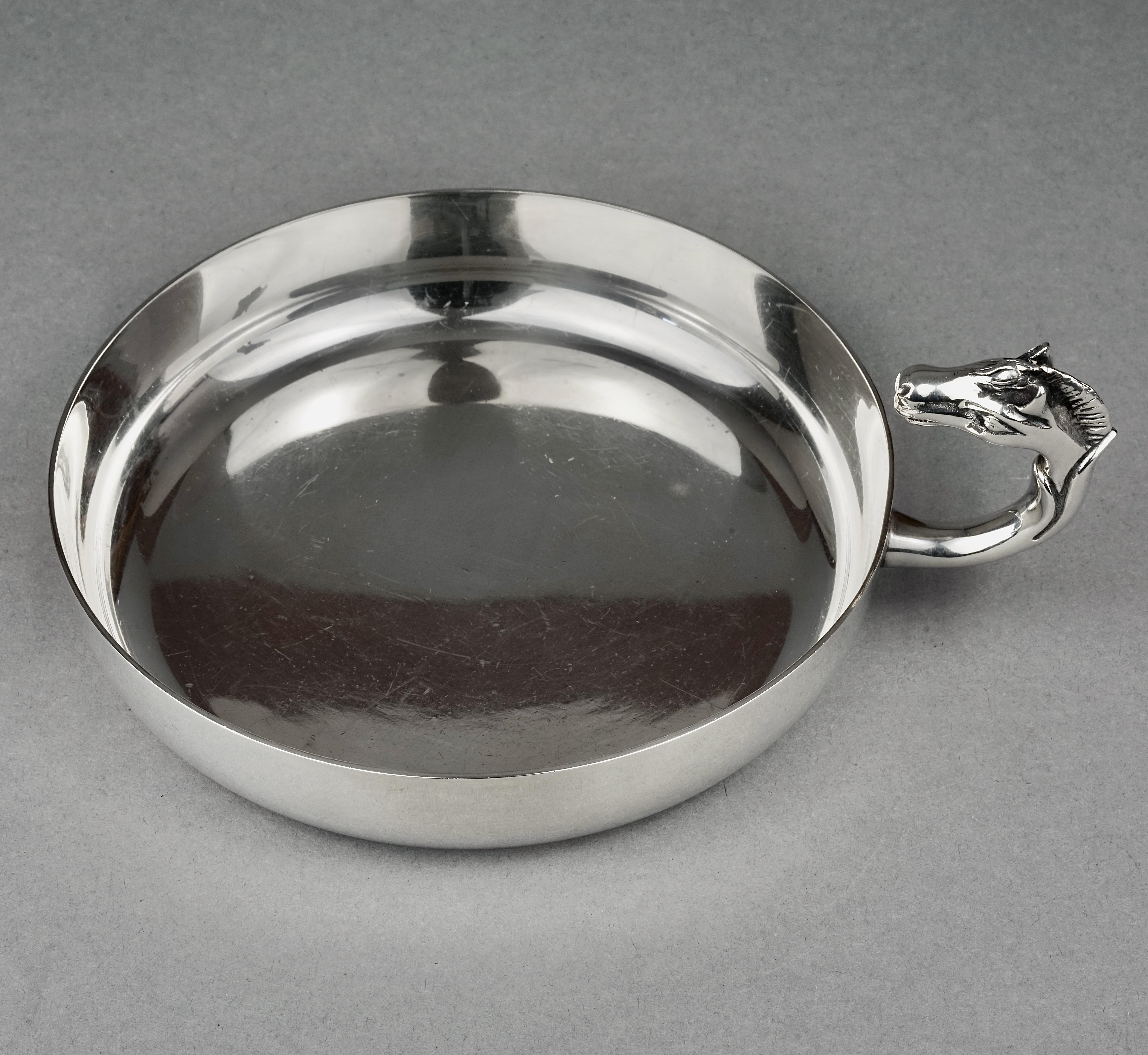Vintage HERMES Catch All Horse Head Silver Tray Dish by Ravinet d'Enfret

Measurements:
Total Height: 2.44 inches (6.2 cm) with horse head
Diameter: 5.59 inches (14.2)

Features:
- 100% Authentic HERMES.
- Horse head handle.
- Silver tone.
- Signed