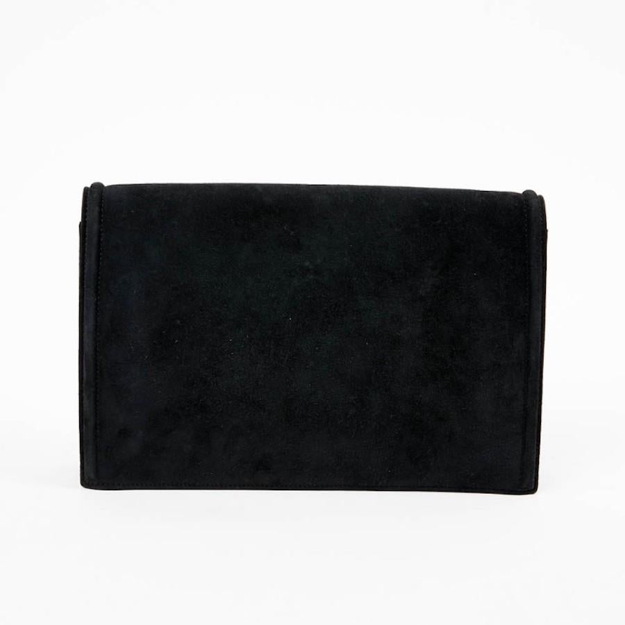This is a pretty vintage HERMES pouch in black suede lined with leather. The jewelry  is in old silver metal. On the clasp small crystals but some are missing (barely visible). The topstitch is black. When you open the clutch you read 