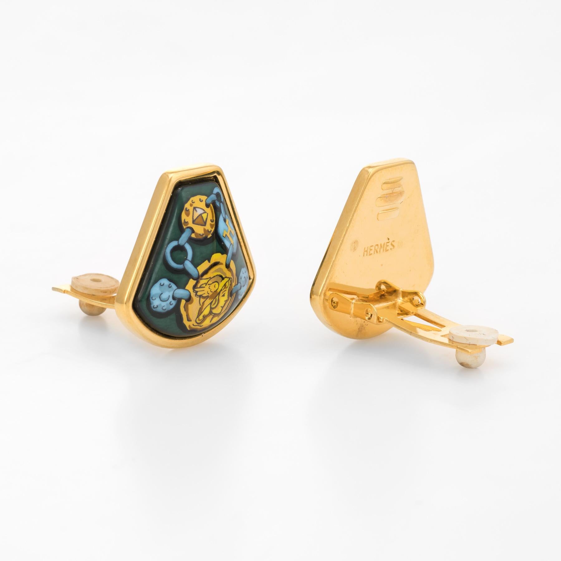 Finely detailed pair of Hermes enamel clip earrings, crafted in yellow gold tone. 

Vibrant green and gold colors, with the distinct Hermes linked design, terminating to a central motif of a female gladiator. The enamel is in excellent condition and