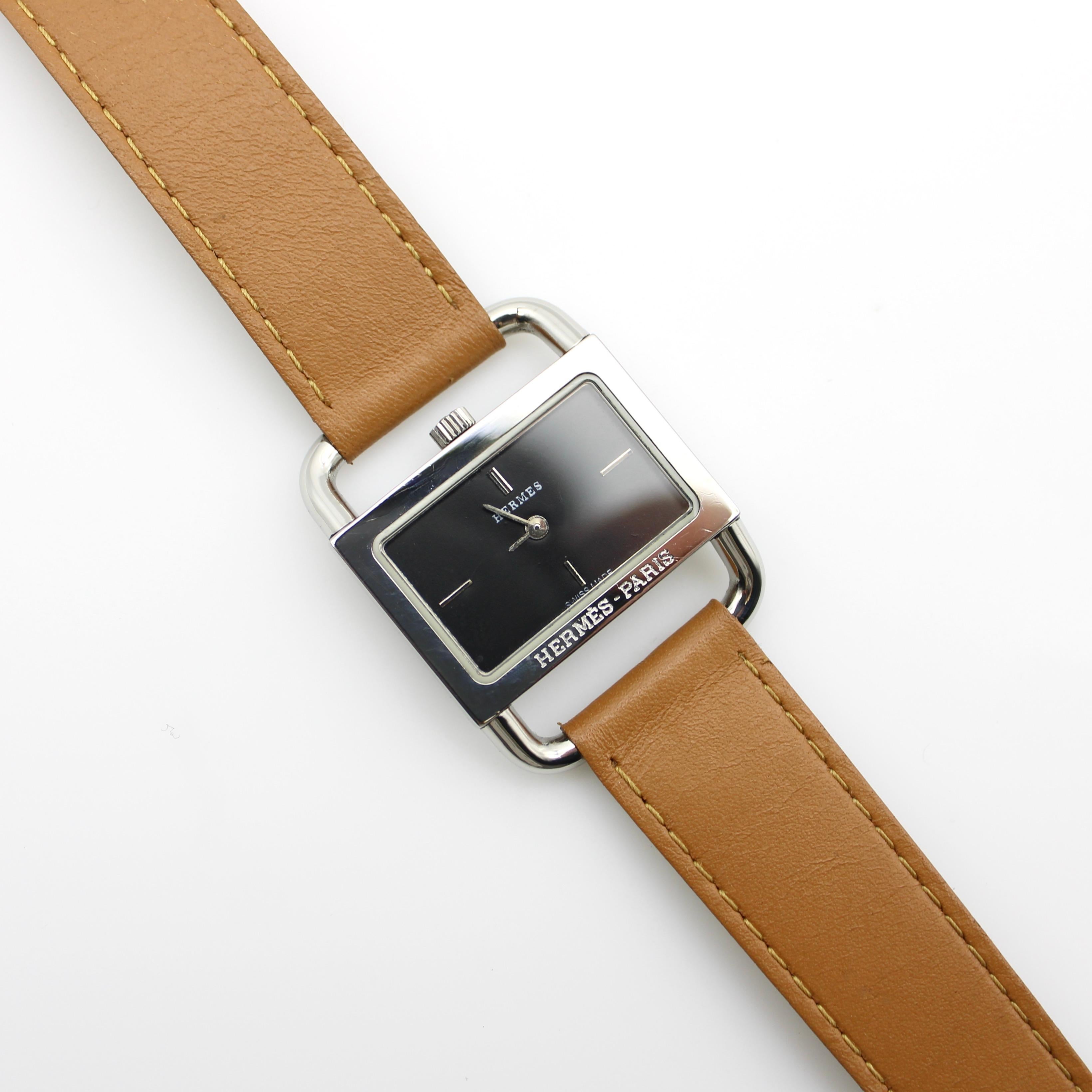 An elegant vintage Parisian-made Hermès wrist watch with quartz battery movement, circa 1980. The watch’s minimal style is refined, with four simple lines at noon, 3, 6, and 9 to denote the time. The exterior of the watch is stainless steel, which
