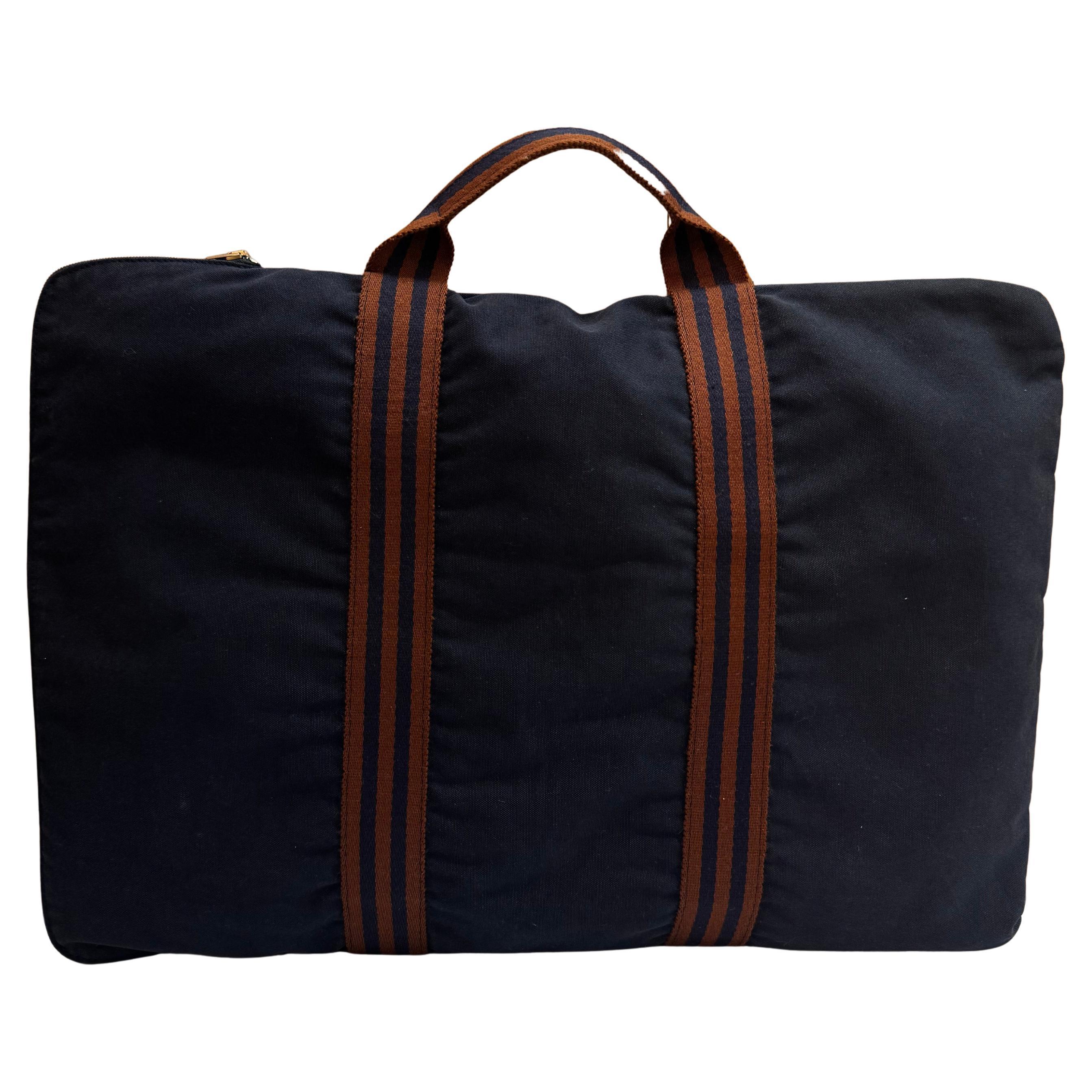 This vintage HERMES Fourre Tout flat portfolio tote bag is crafted of cotton in navy featuring a sturdy handle of stripe canvas. Side zipper closure opens to a navy cotton interior. This sophisticated Hermes piece is the perfect tote for your laptop