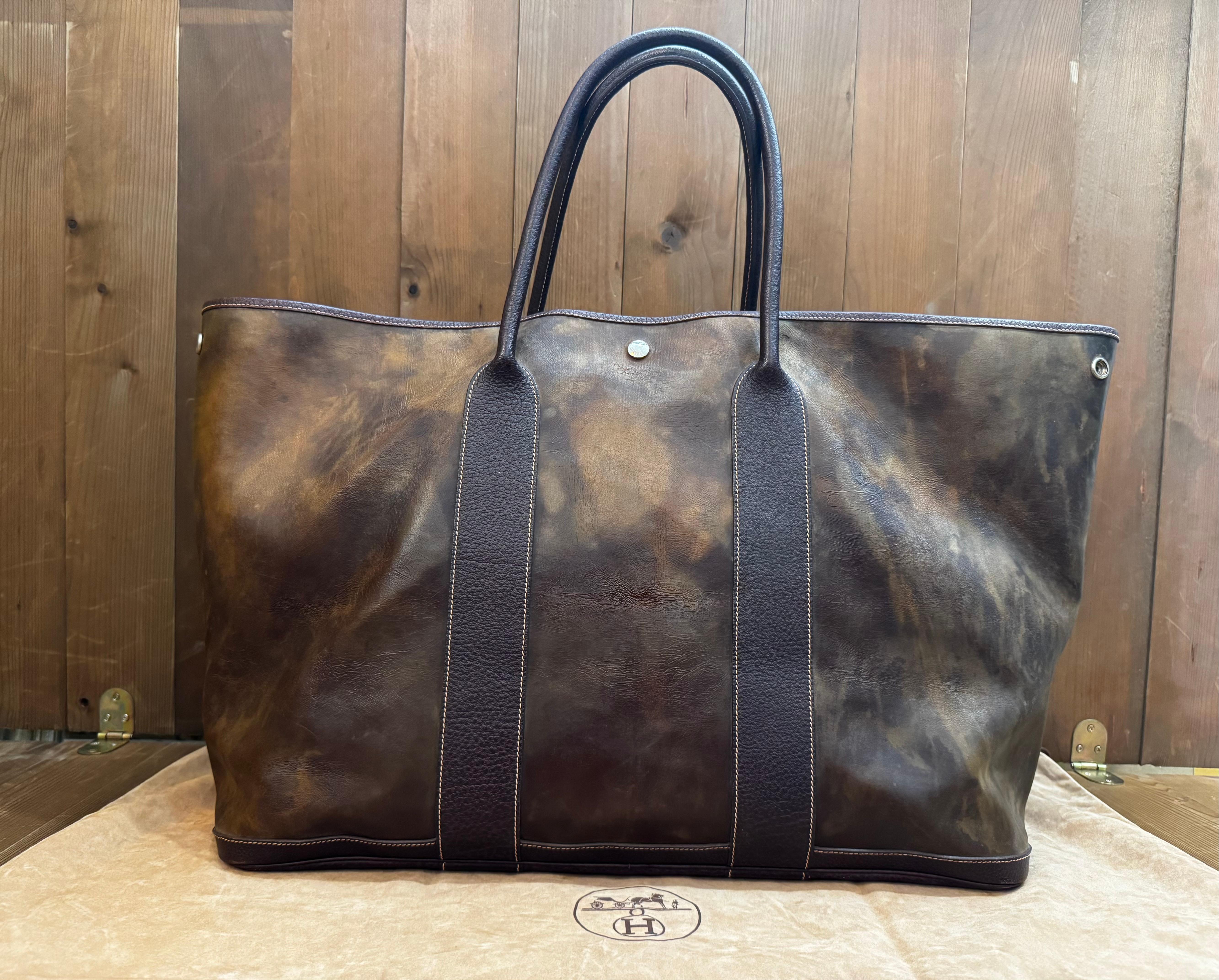 This vintage HERMES Garden Party Amazonia TGM tote bag is crafted of amazonia rubber coated canvas trimmed with large-grained buffalo leather rolled top handles and palladium hardware. Wide top palladium snap closure opens to a spacious herringbone
