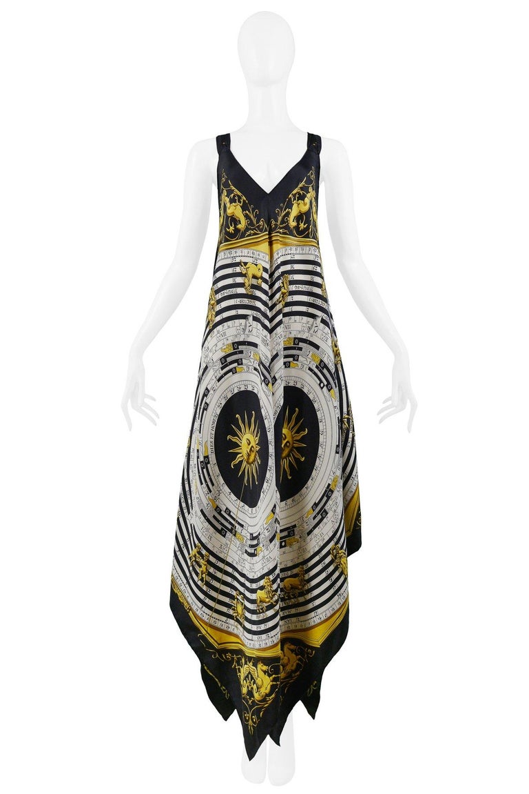 Resurrection Vintage is excited to present a vintage Hermes black, gold, and white silk scarf dress featuring a deep V neckline, wide straps, handkerchief point hem, and iconic Hermes zodiac print. Fabric is printed 