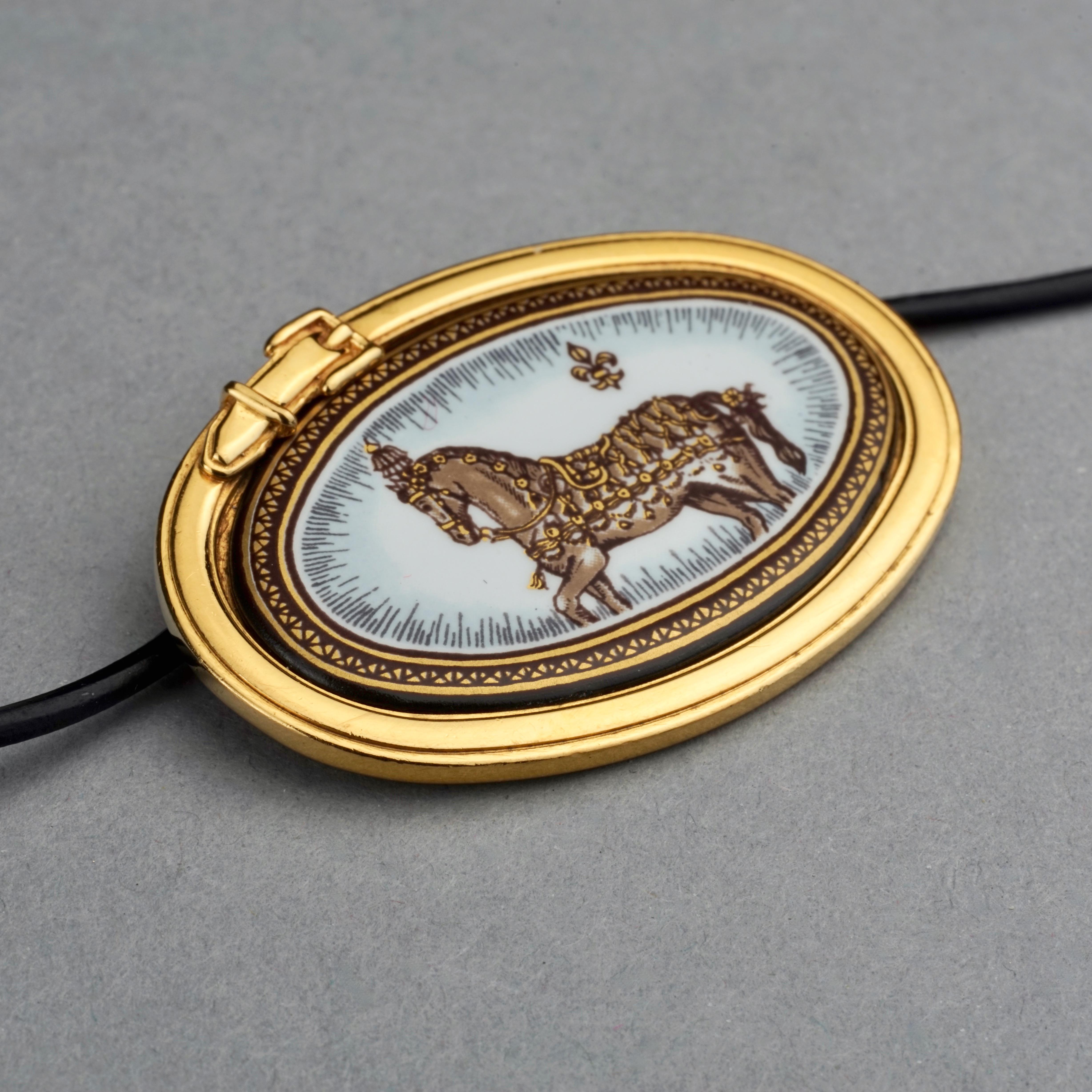 Vintage HERMES Horse Enamel Pendant 

Measurements: 
Height: 1.18 inches (3 cm)
Pendant Width: 1.77 inches (4.5 cm)

Features:
- 100% Authentic HERMES.
- Iconic horse print enamel pendant.
- Gold tone hardware.
- Black strap (not from Hermes) ties