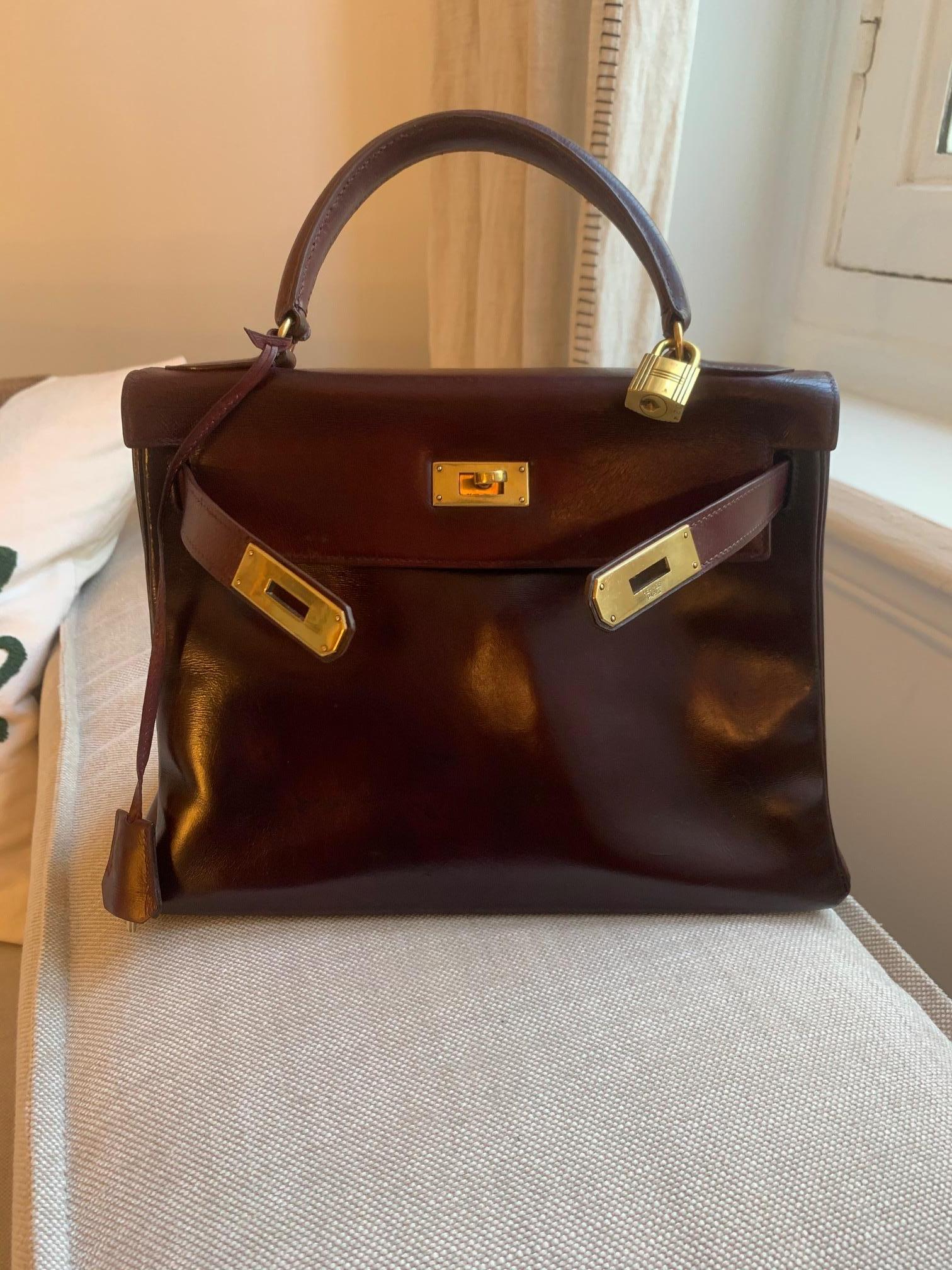 Beautiful VINTAGE Hermes Kelly 28 cm from 60's. 
Burgundy calfskin handbag, gold plated metal hardware, burgundy leather handle for carrying.

Closure by flap.
Lining in burgundy leather, one zippered pocket, two patch pockets.
Signature: 