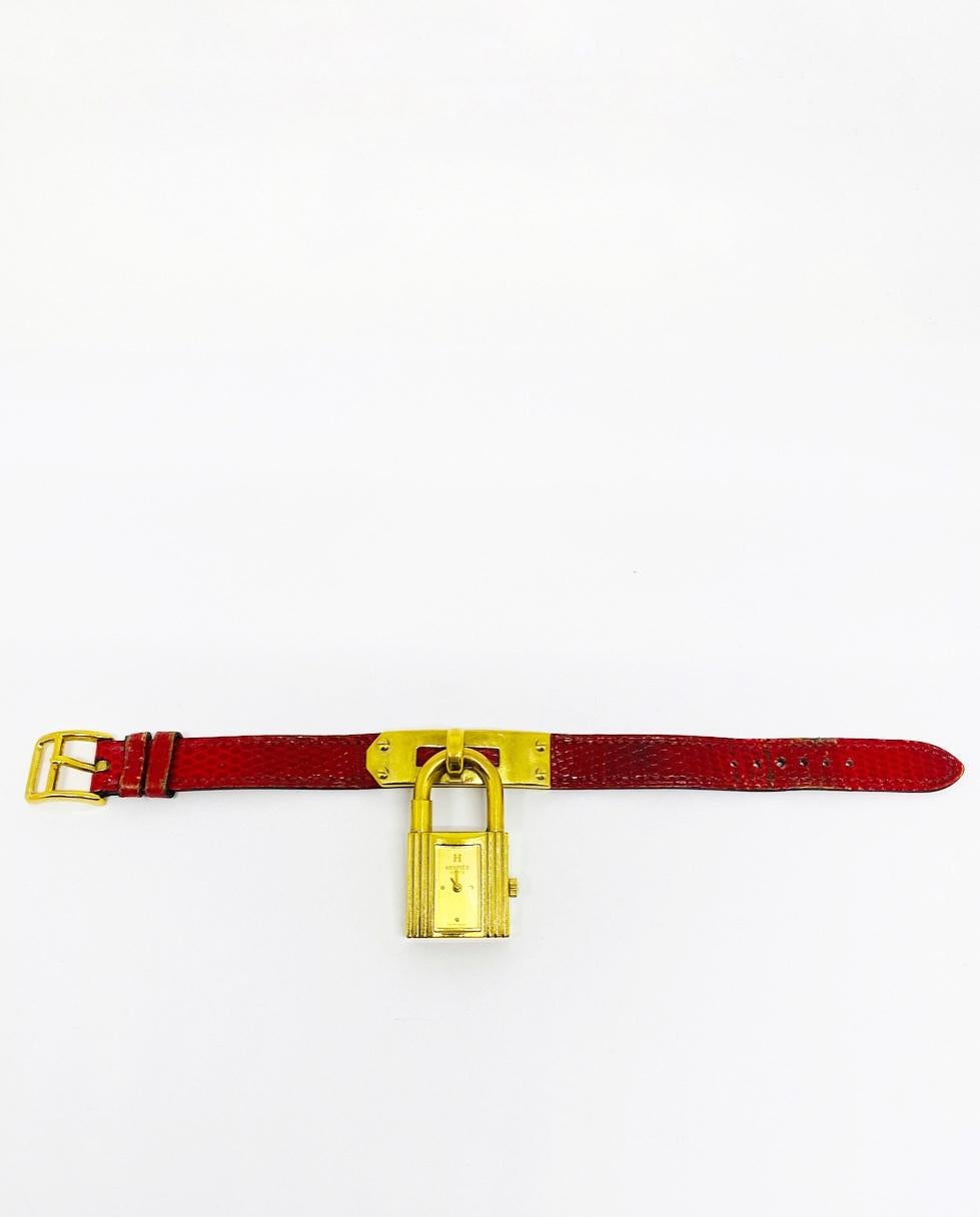 Vintage HERMES Kelly Gold Padlock Wristwatch Red Animal Skin Strap Bracelet

Product details:
Gold plated 
The lock is stamped with the serial number: 418628
Red lizard/ animal skin strap 
The bracelet is 7.25” long and 0.25” wide 
The bracelet is