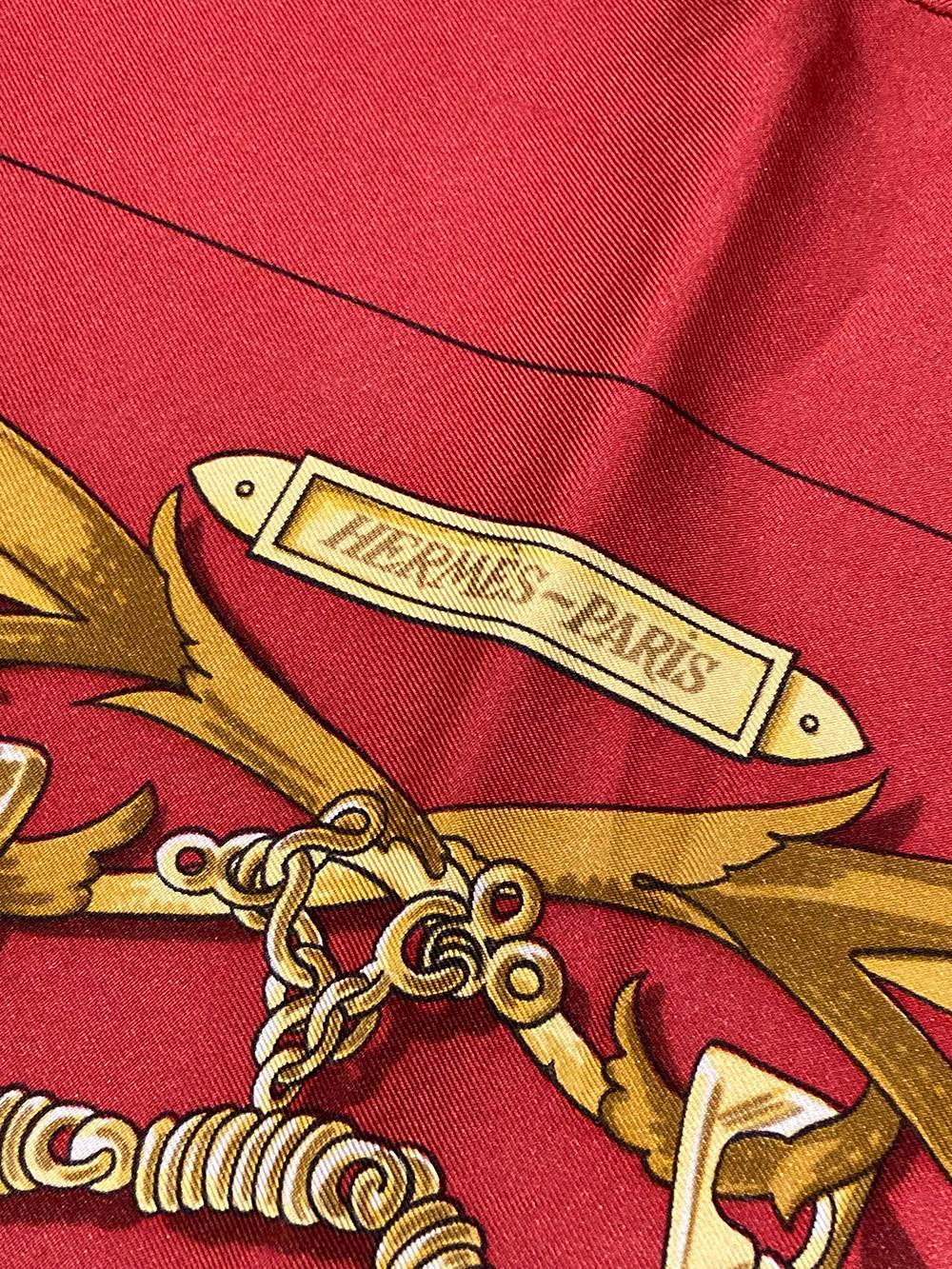 Vintage Hermes Le Mors A La Conétable silk scarf in Red c1970s in very good condition. Original silk screen design c1970 by Henri d'Origny features a beautiful gold ribbon design over a deep red background. 100% silk, hand rolled hem. signed by