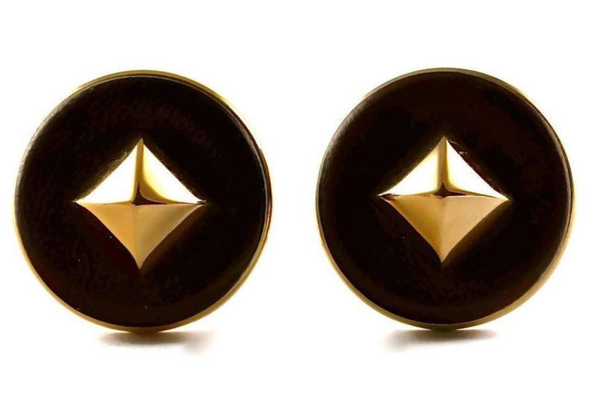 Vintage HERMES Medor Leather Pyramid Stud Earrings

Measurements:
Height: 1 3/8 inches (3.49 cm)
Width: 1 3/8 inches (3.49 cm)

Features:
- 100% Authentic HERMES PARIS.
- Brown lambskin leather.
- Pyramid stud at the centre.
- Gold tone.
- Clip back