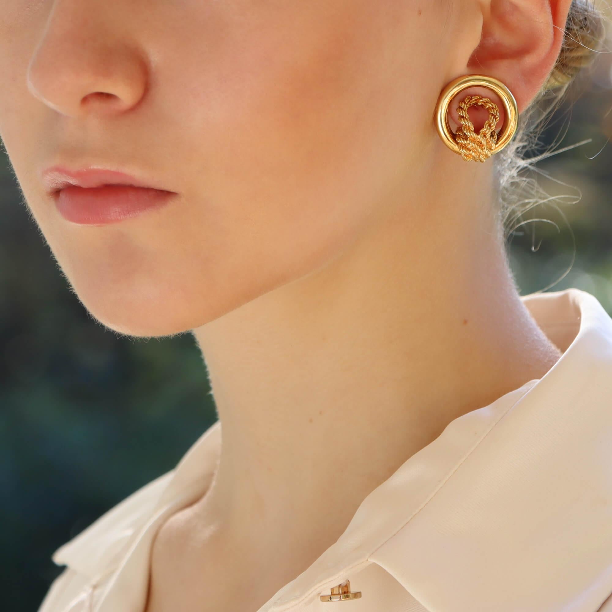  A spectacular pair vintage Hermès circular knotted rope earrings set in 18k yellow gold.

Each earring centrally features the iconic Hermès knot motif which is beautifully designed with ridged engraved detailing. Surrounding the knot is a solid